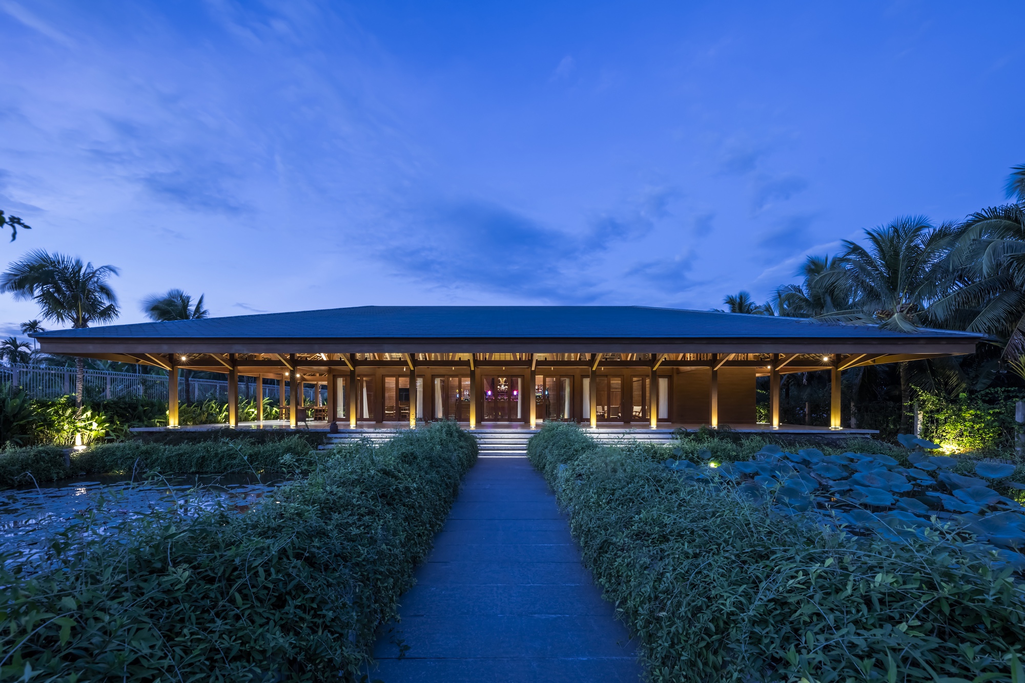 Garden approach to the pavilion at twilight with pathway through planted beds