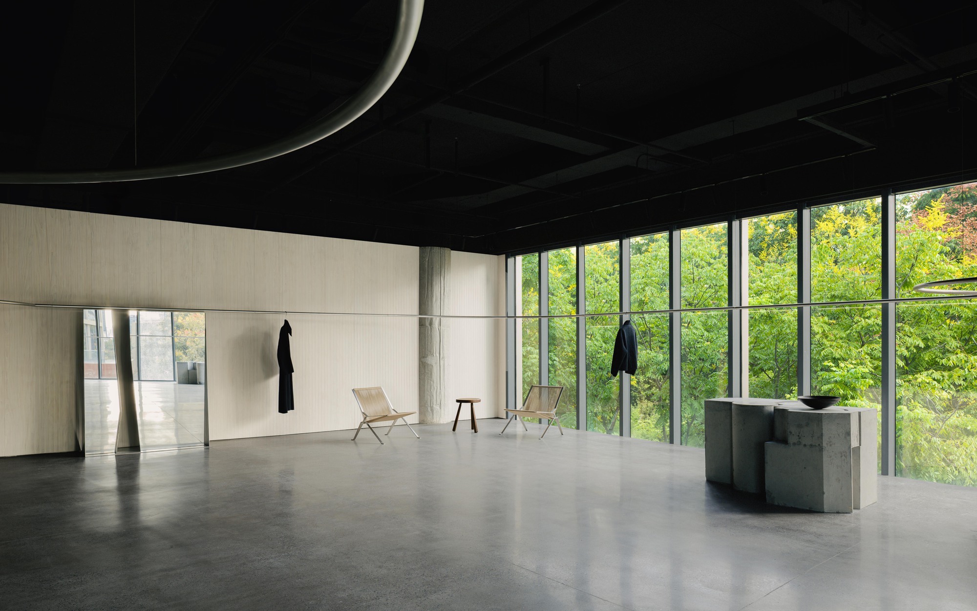 Polished concrete floor reflecting daylight from glazed walls overlooking trees in leaf