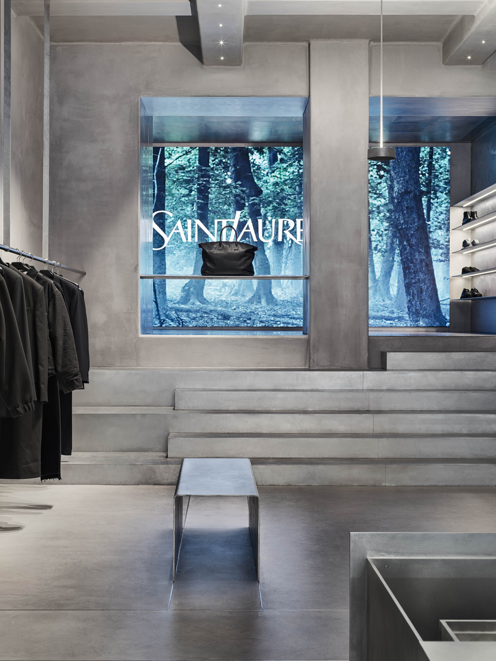 Concrete steps leading to a display window with forest view beyond the glass storefront