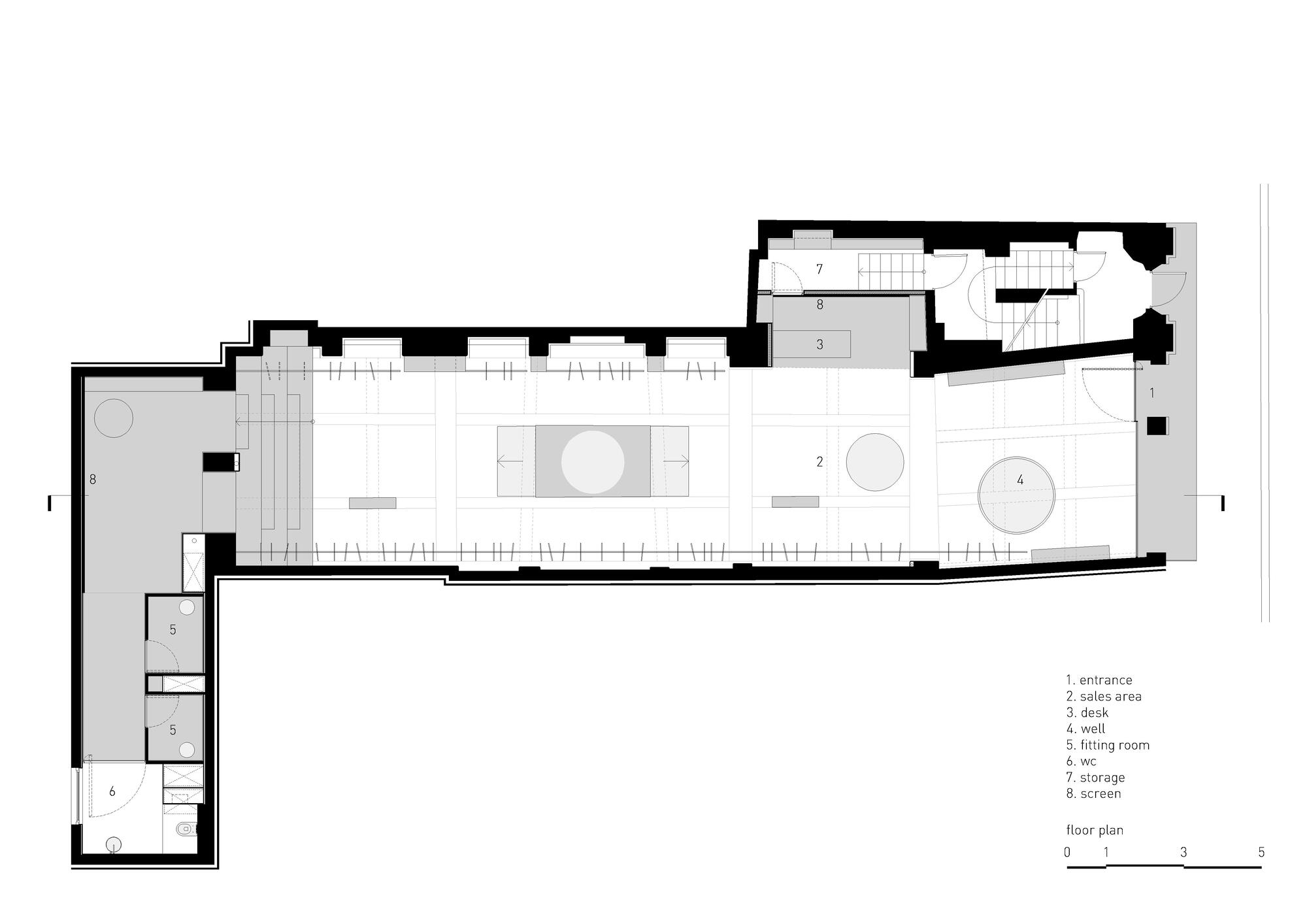Floor plan showing an elongated retail space with two circular display zones and rear staircase