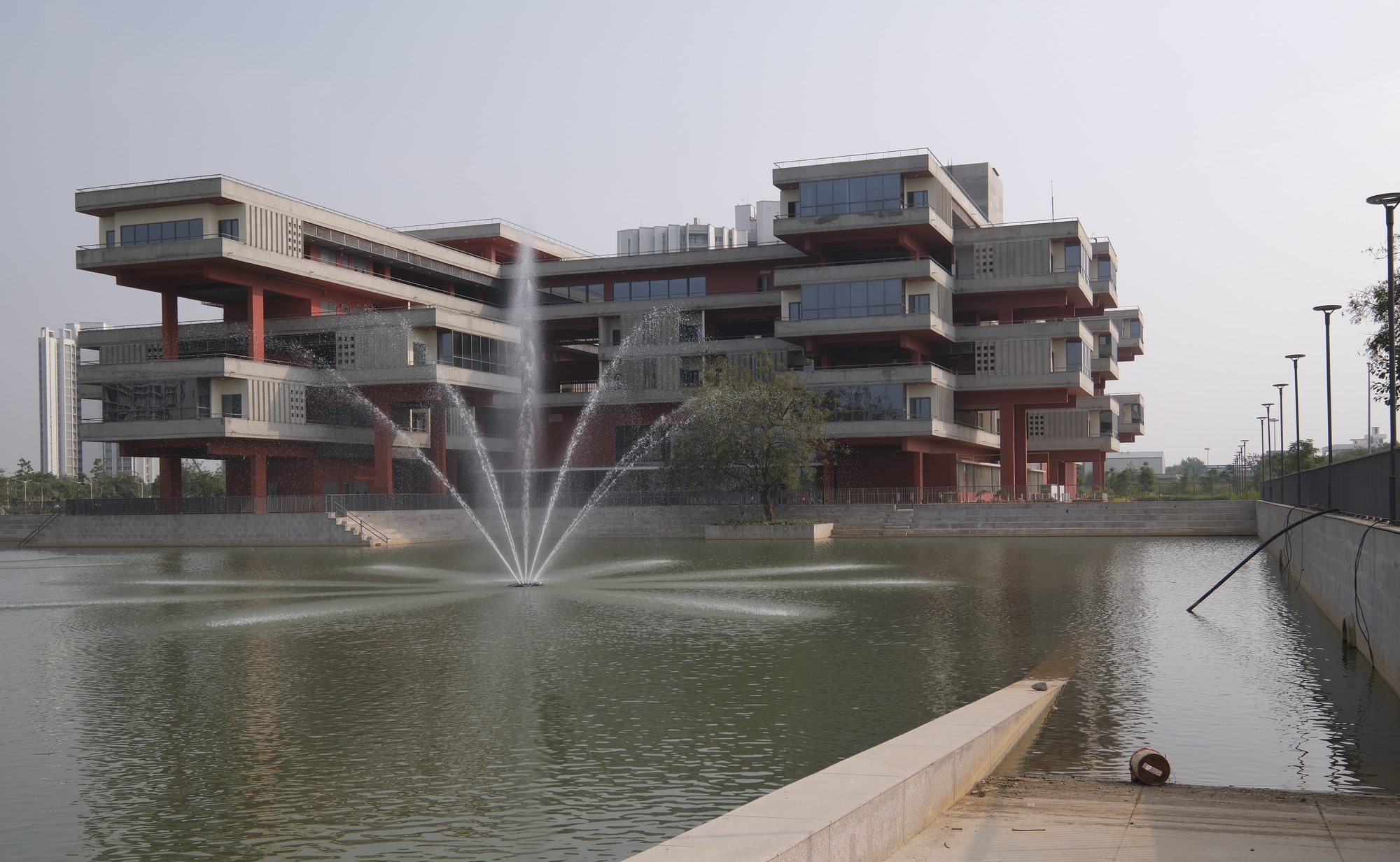 View of the guest house from across the campus reflecting pool with a fountain in the foreground