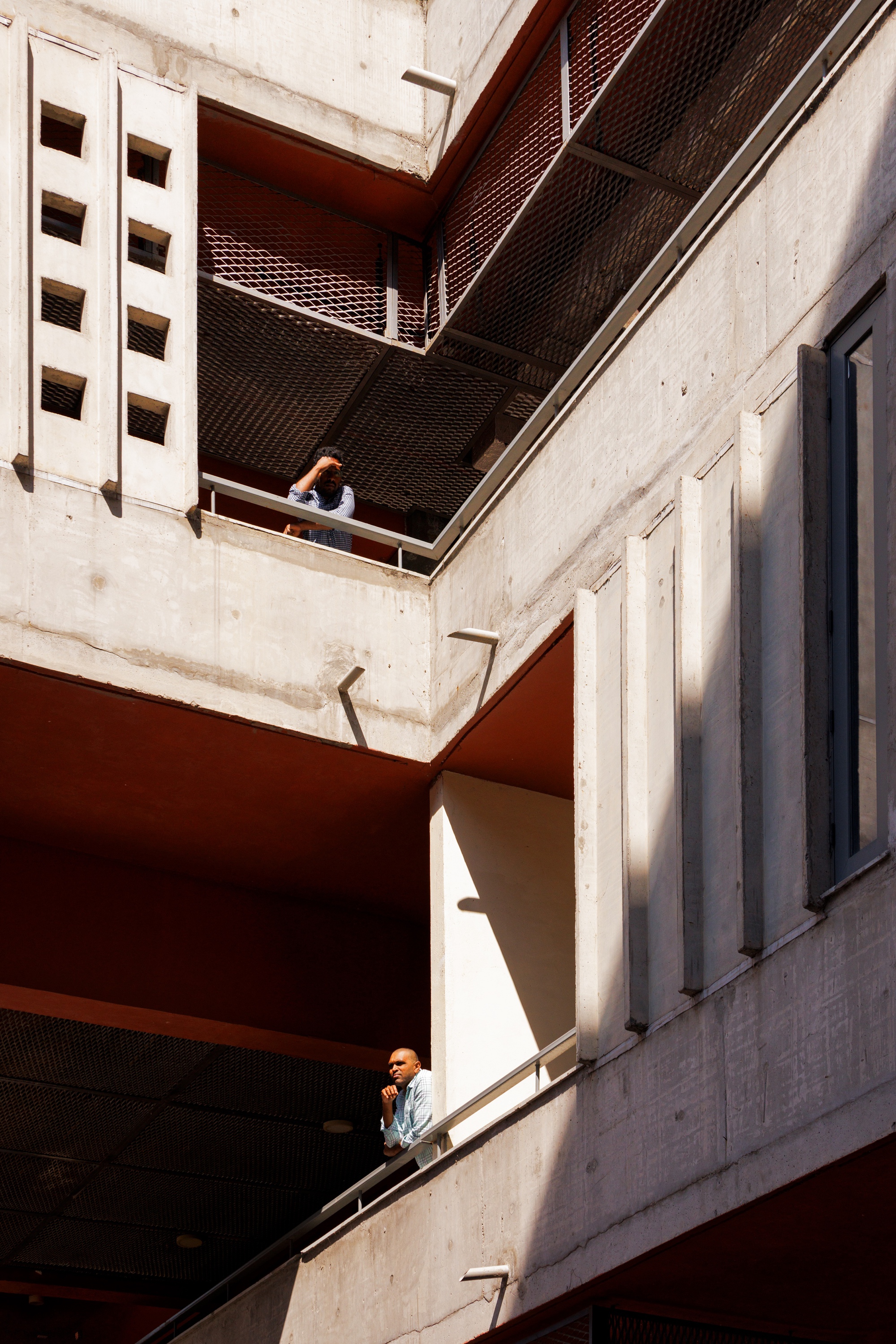 Concrete circulation balconies seen between the wings, with a figure on each level