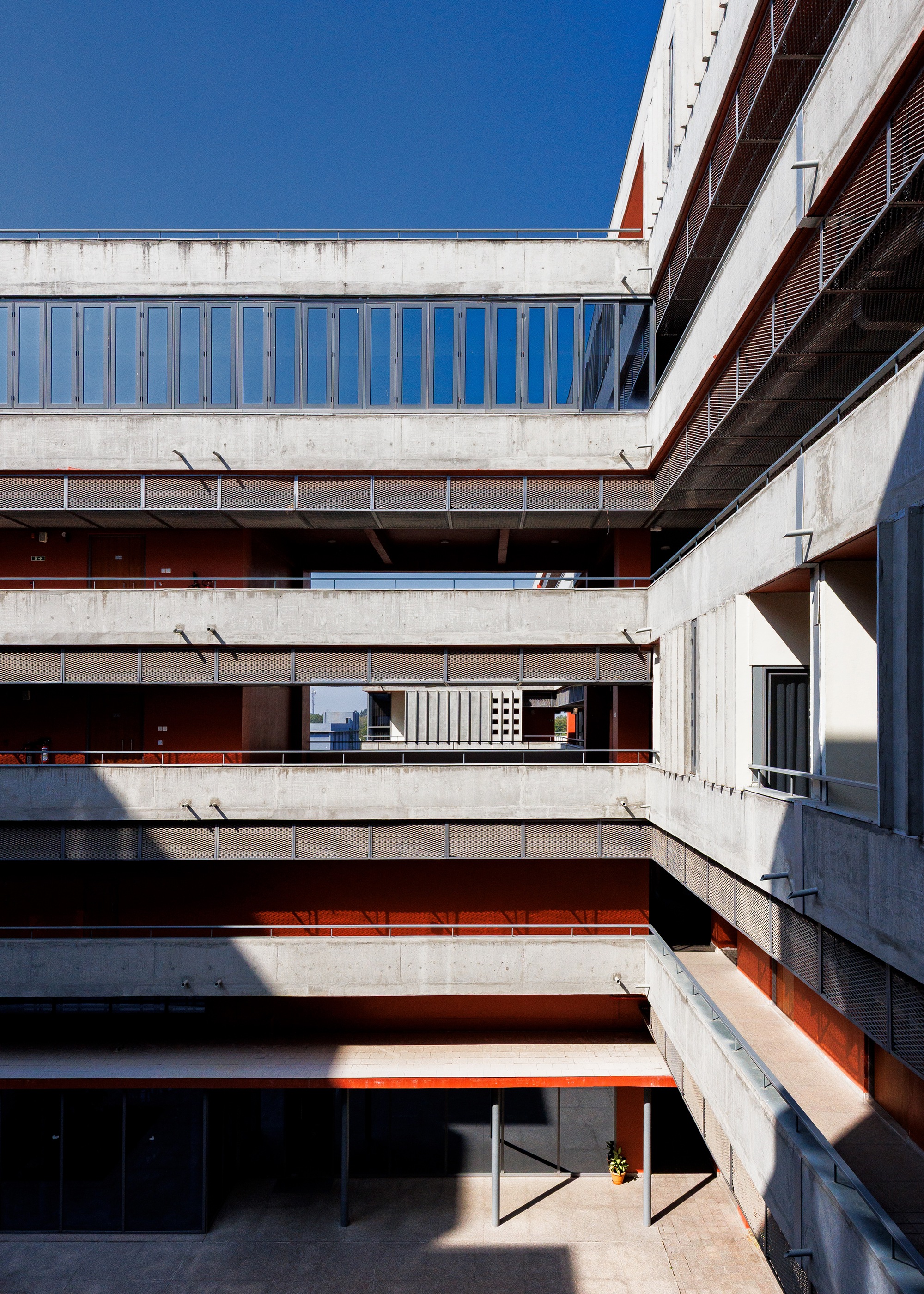 Internal courtyard slot with the layered concrete and red surfaces