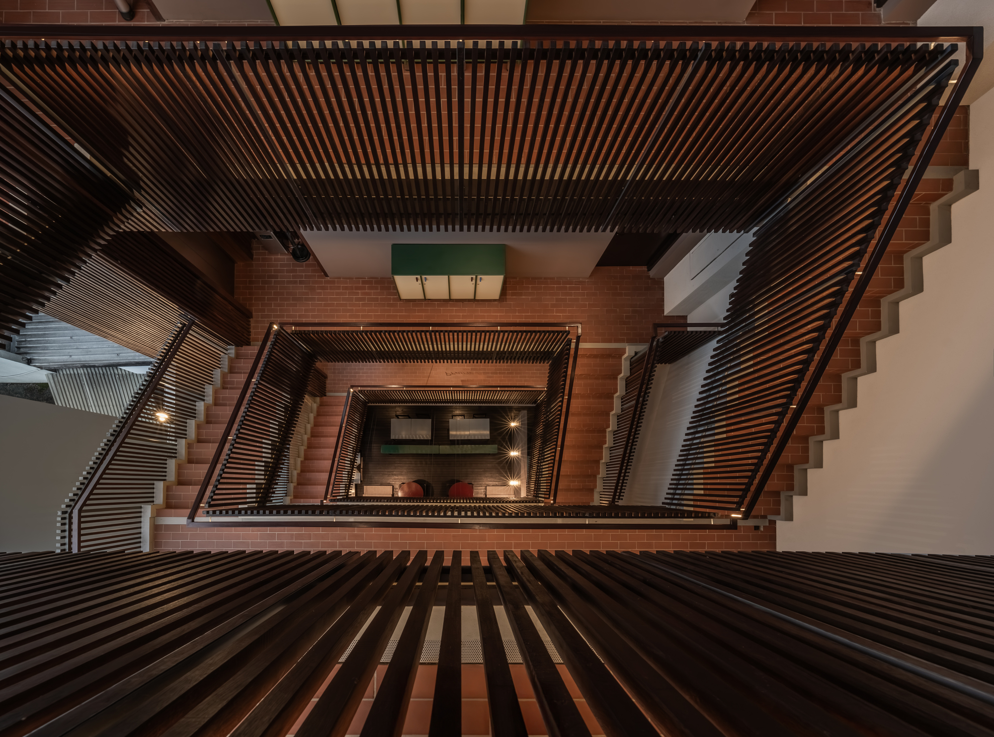 Top-down view of the central stair void with slatted screens and terracotta tile steps