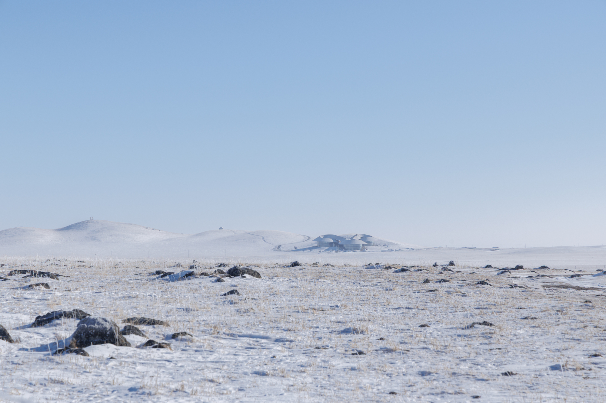 Wide view of the bare grassland horizon with low volcanic hills in the distance