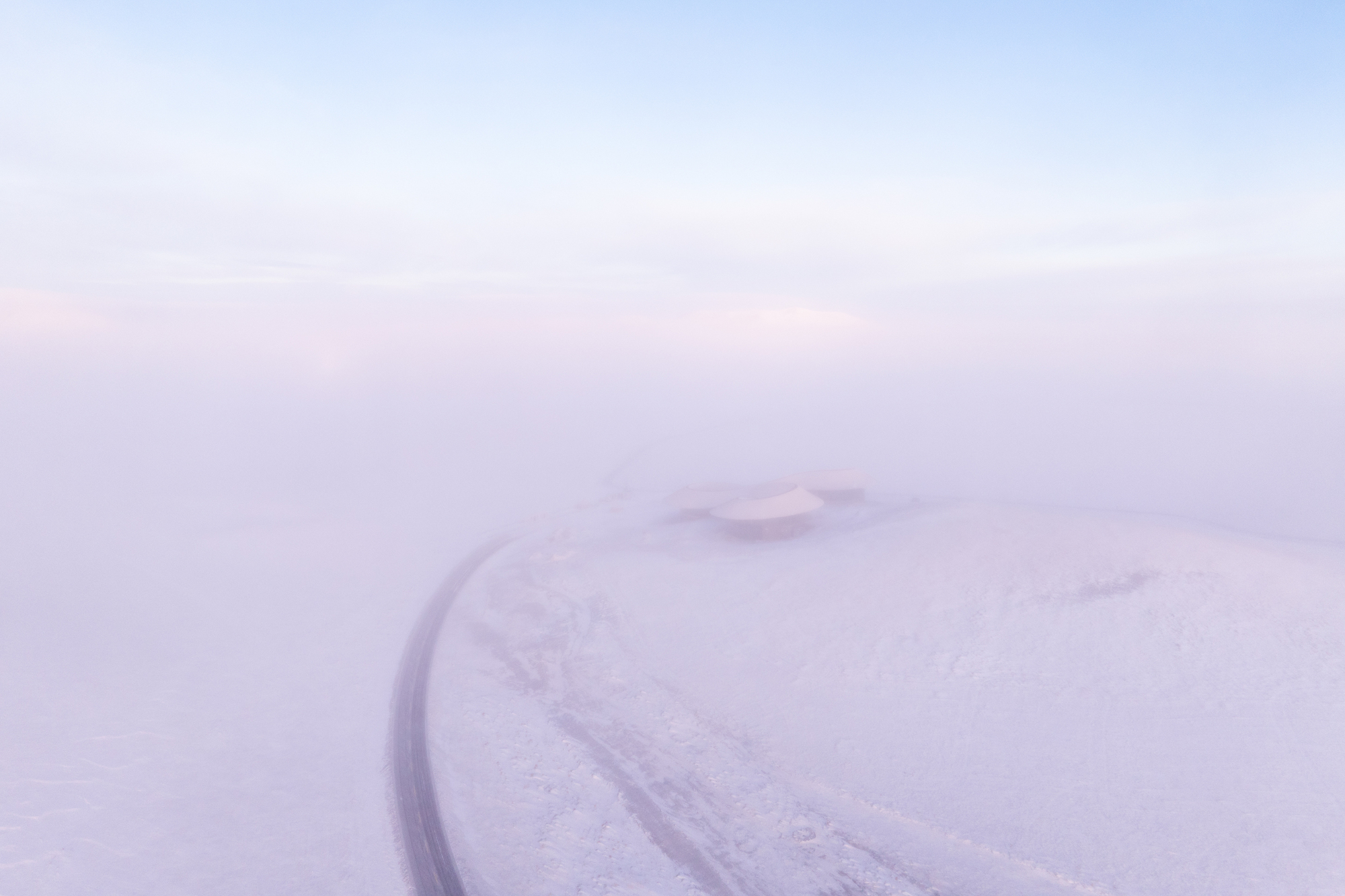 Misty distant view of the volcano cone with the road curving past it