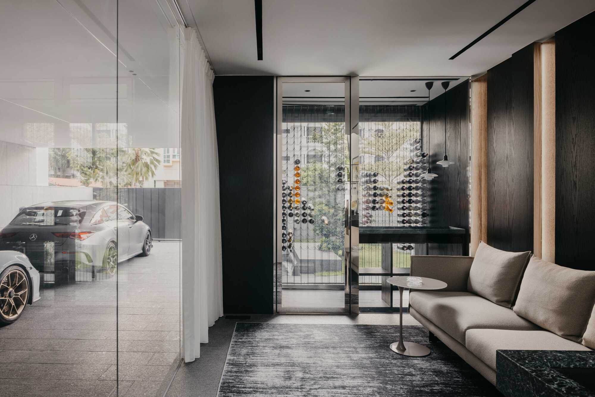 Ground-floor entry with glass wall, dark timber paneling and wine bottle display behind the seating