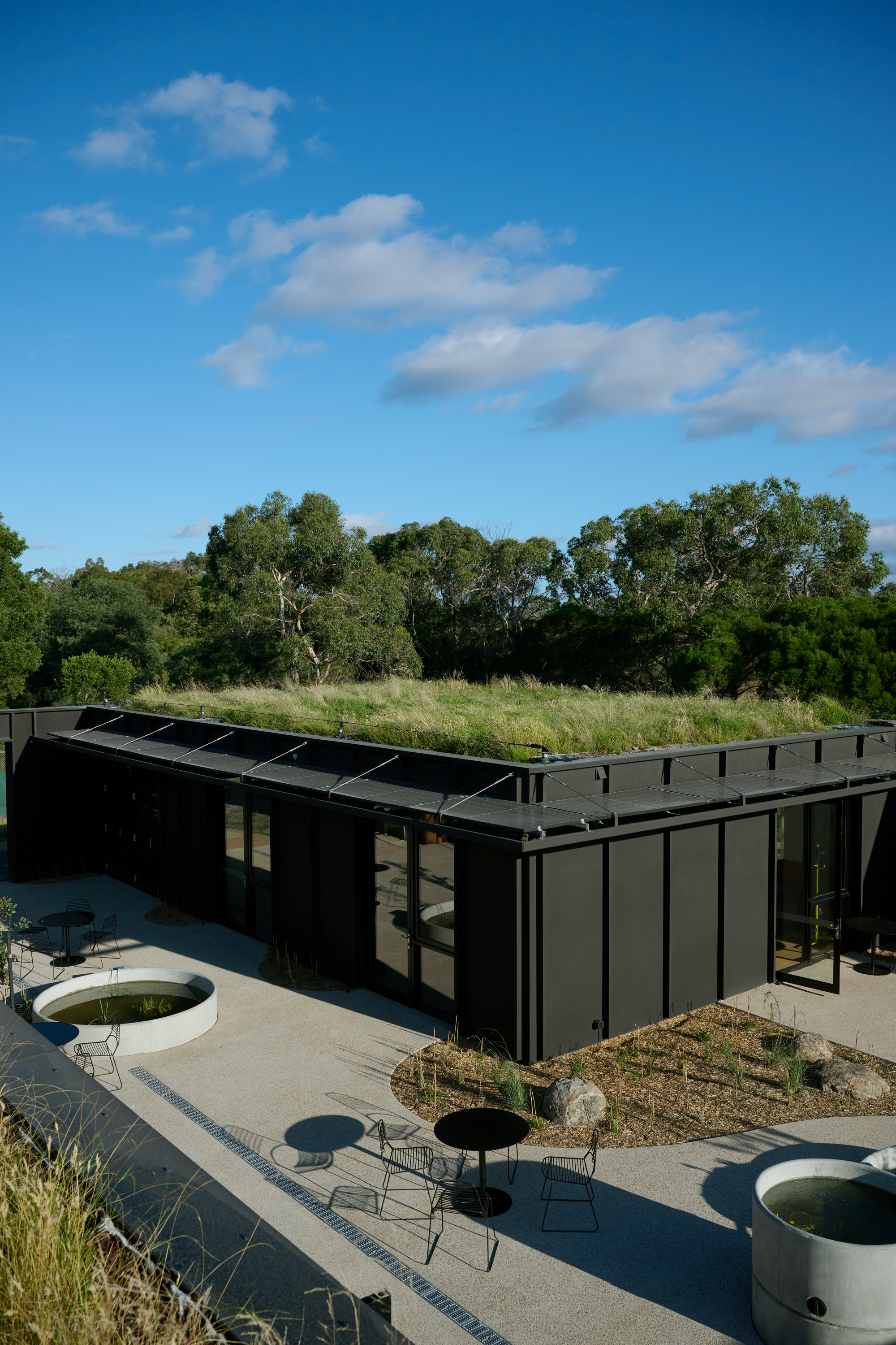 Aerial view of the black-clad wings meeting at an angle with the planted green roof running along the top