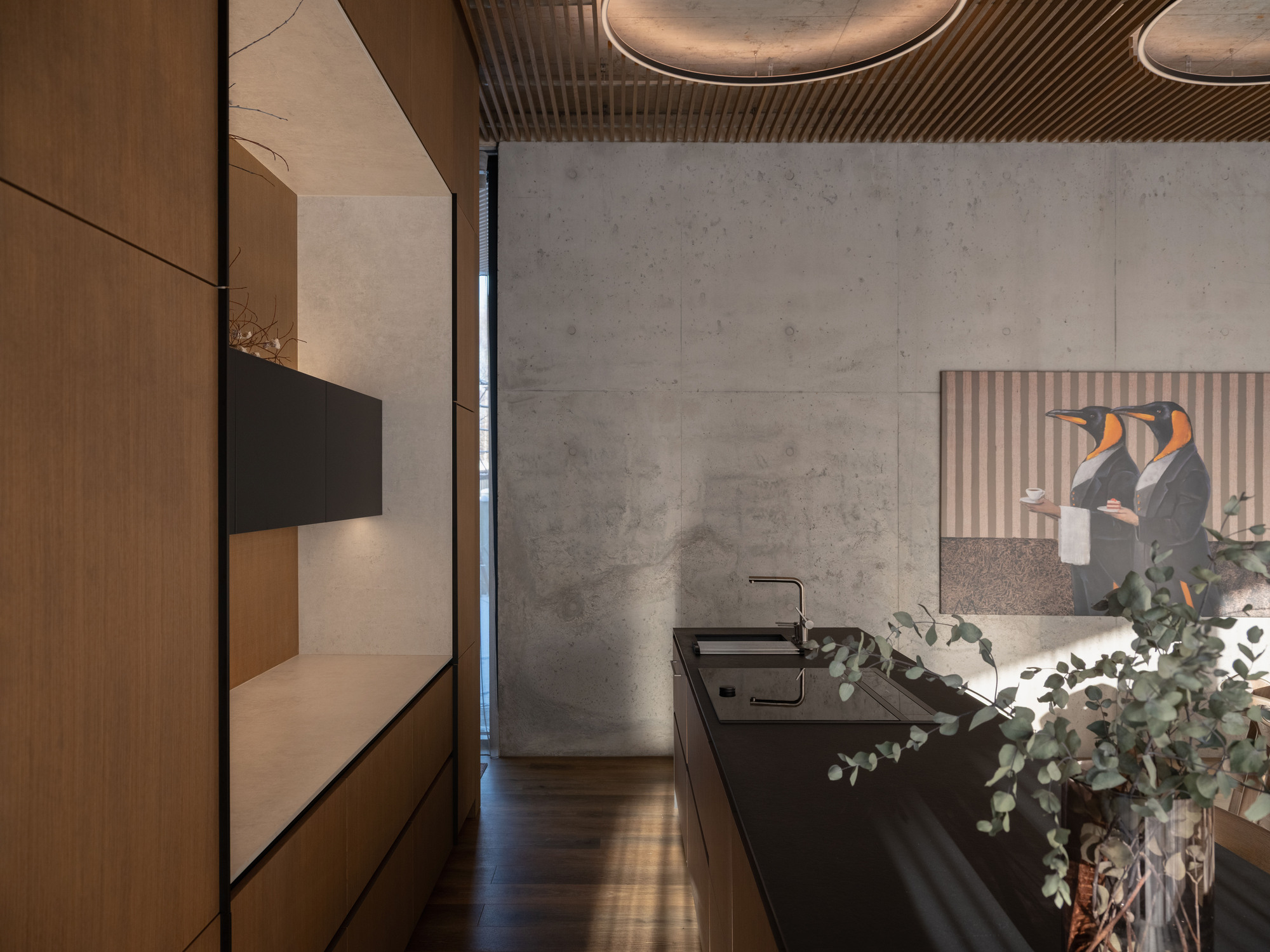 Kitchen with black countertop and concrete wall panels beneath a timber slat ceiling