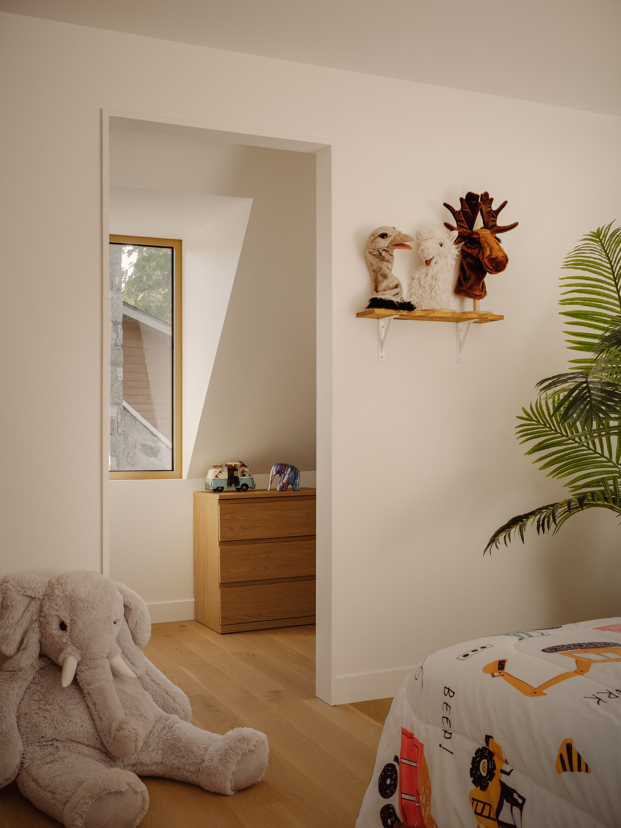 Doorway through white walls leading to an adjacent room with a narrow vertical window