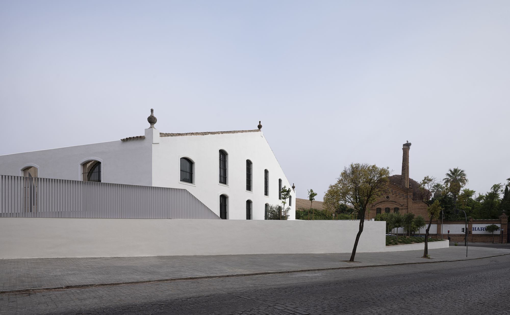 Whitewashed gable end of the historic bodega rising above the new perimeter wall