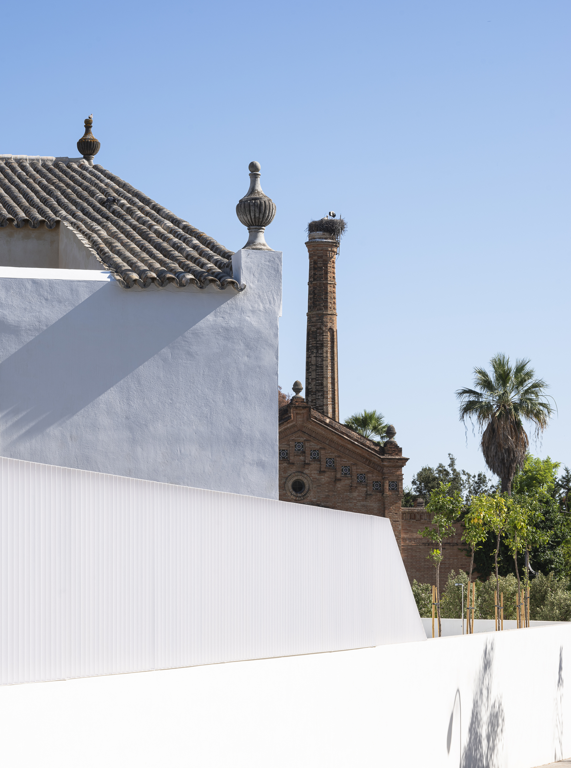 Original tiled roof and finials seen against the neighbouring brick chimney