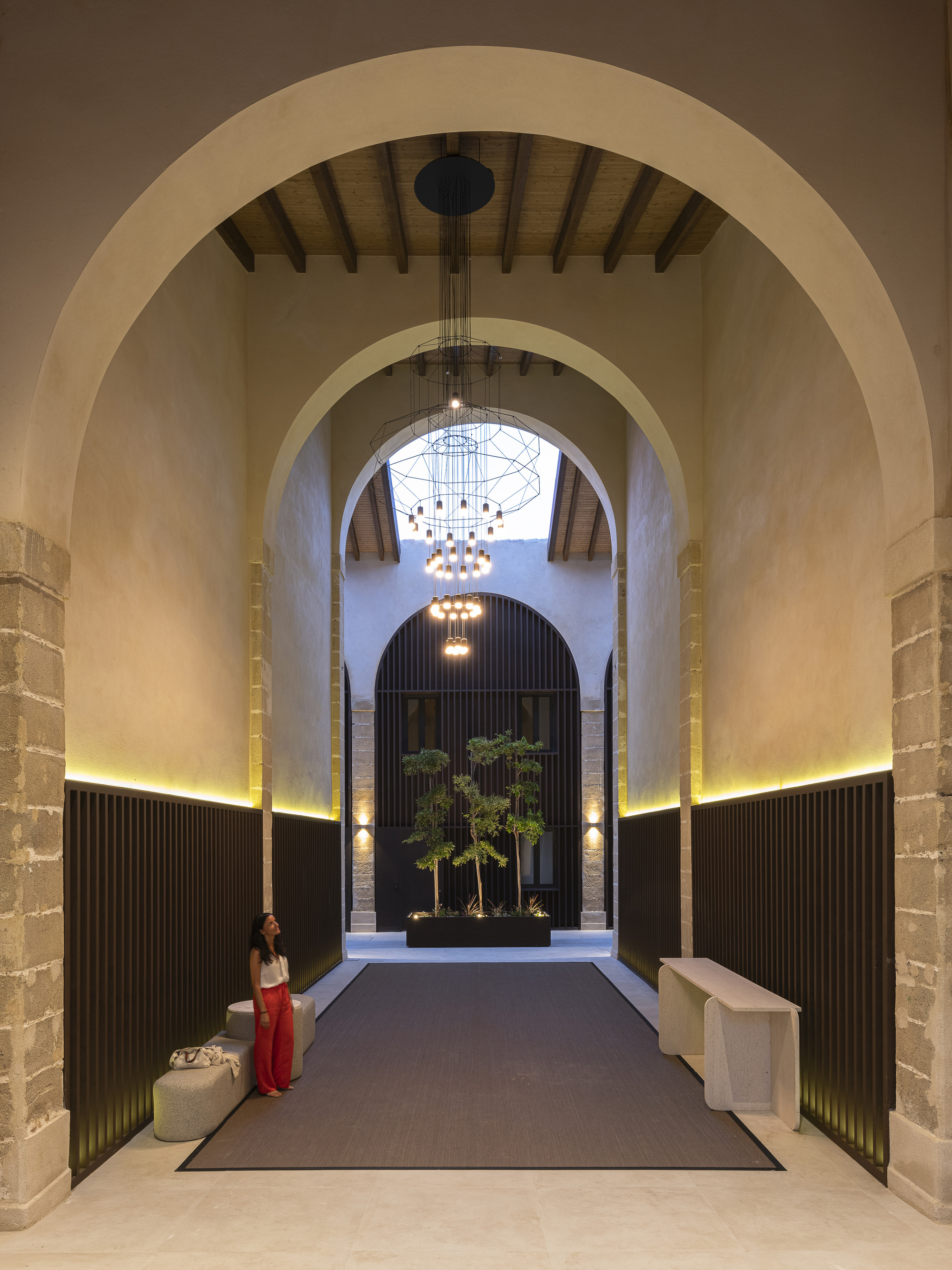 Vaulted entrance hall with tiered chandelier and a planted reflecting box