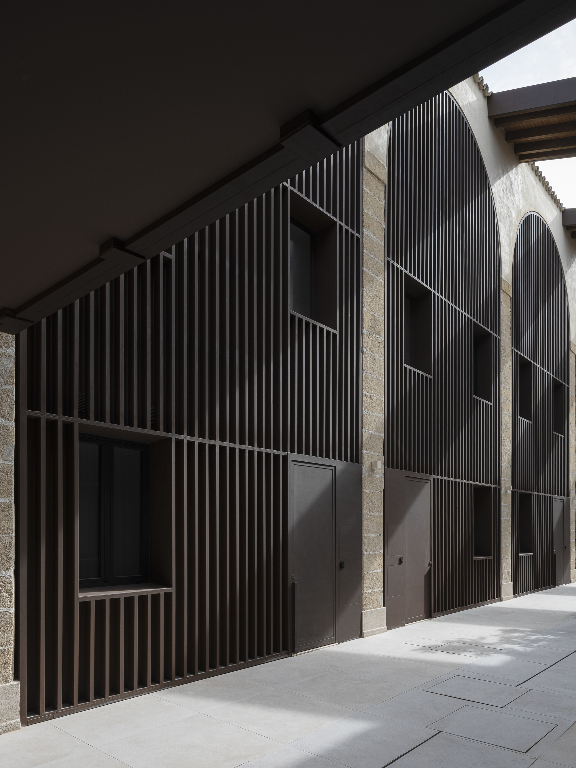 Detail of vertical timber slat screen against original sandstone walls