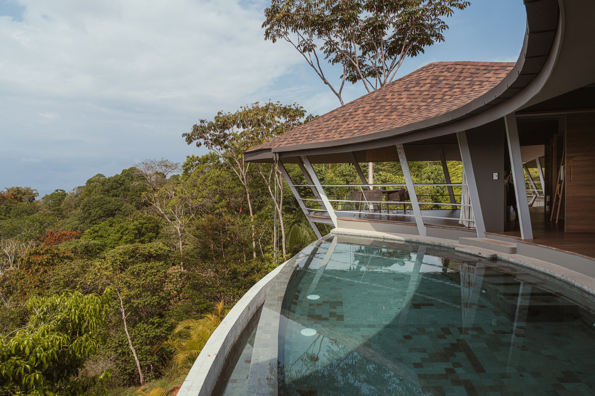 Curved terrace with the small plunge pool cantilevered over the slope toward the jungle