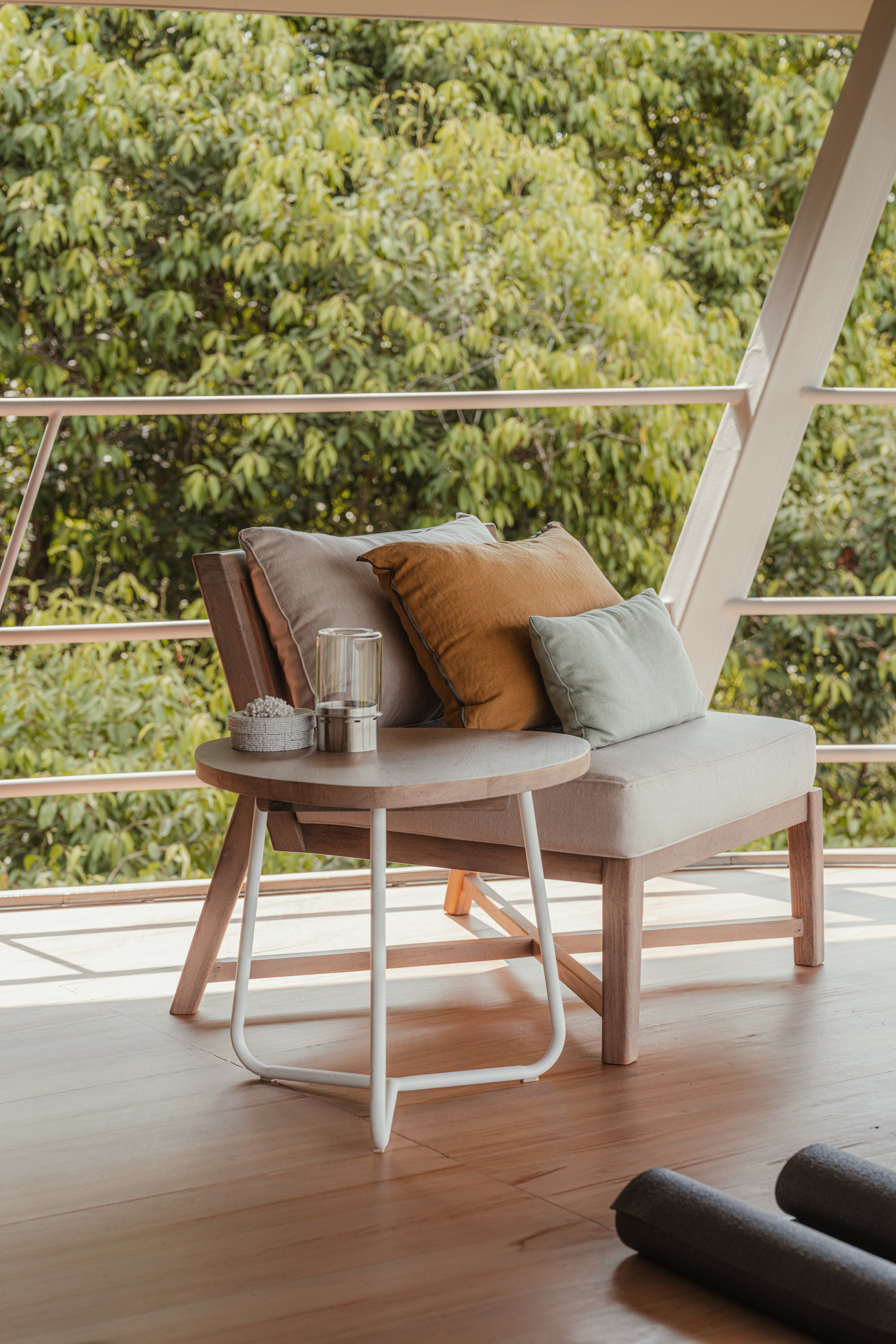 Detail of a reading nook with woven cushions and a small side table overlooking the canopy
