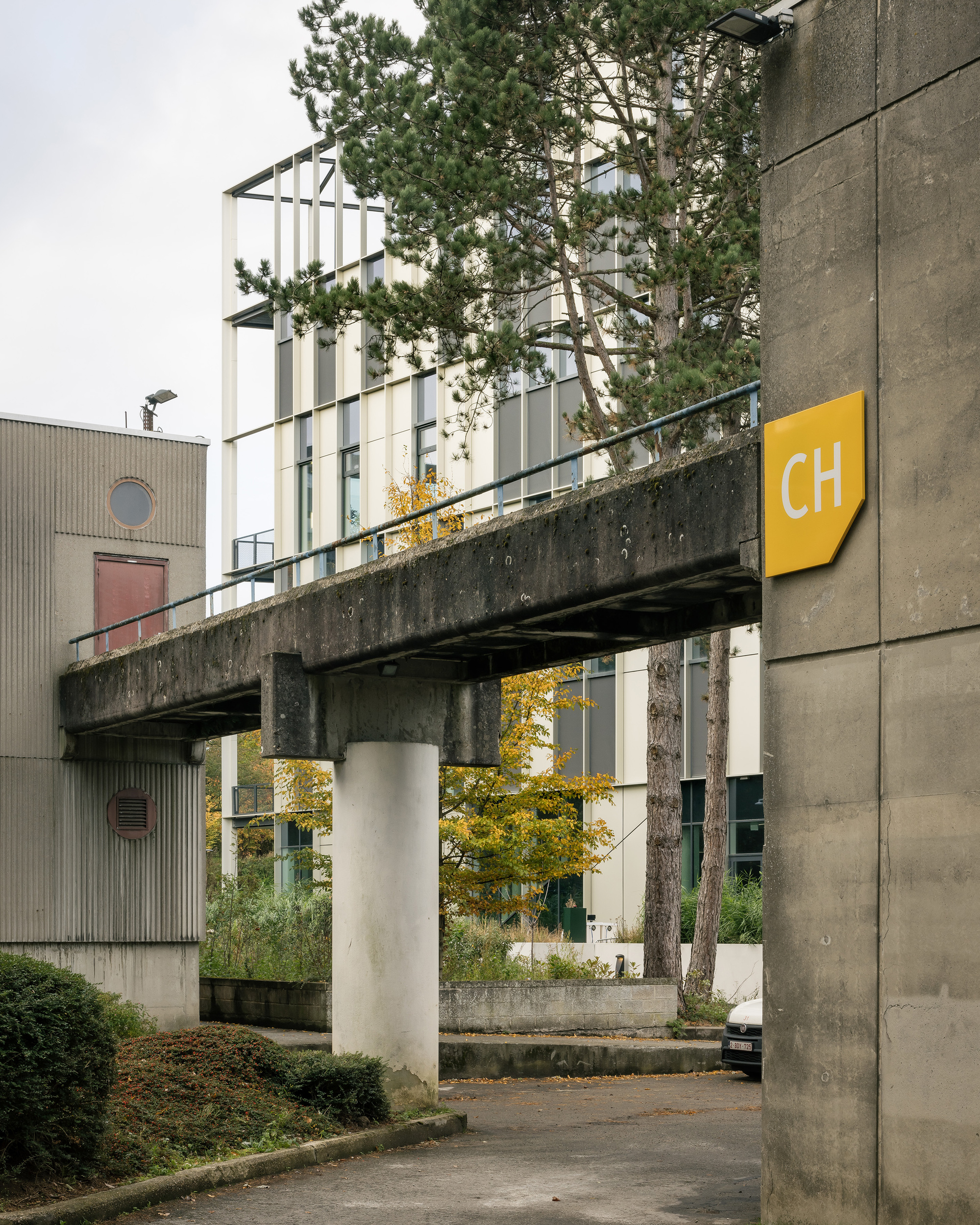 Concrete pedestrian bridge linking the existing campus to the new building