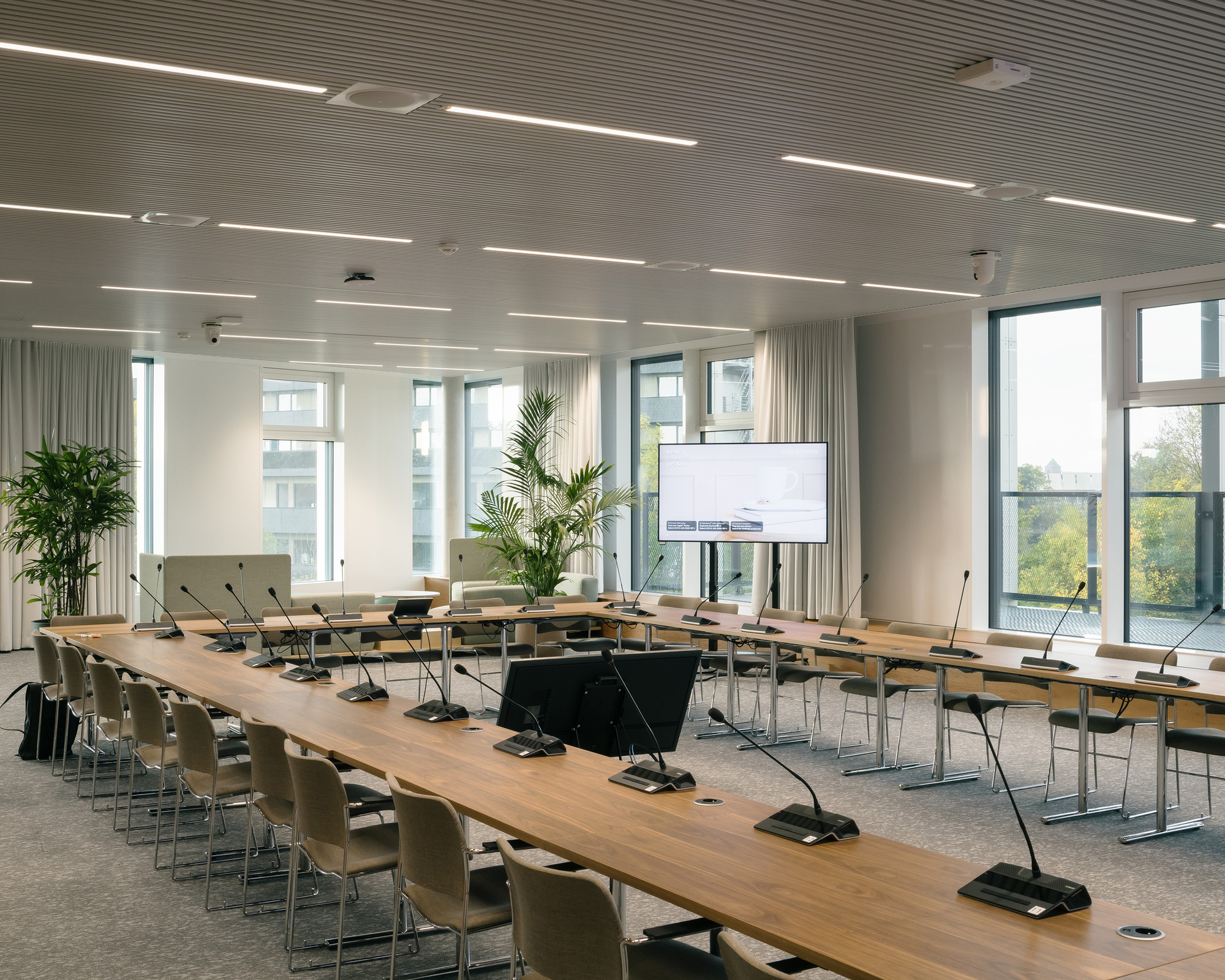 Auditorium with a U-shaped conference table and microphones