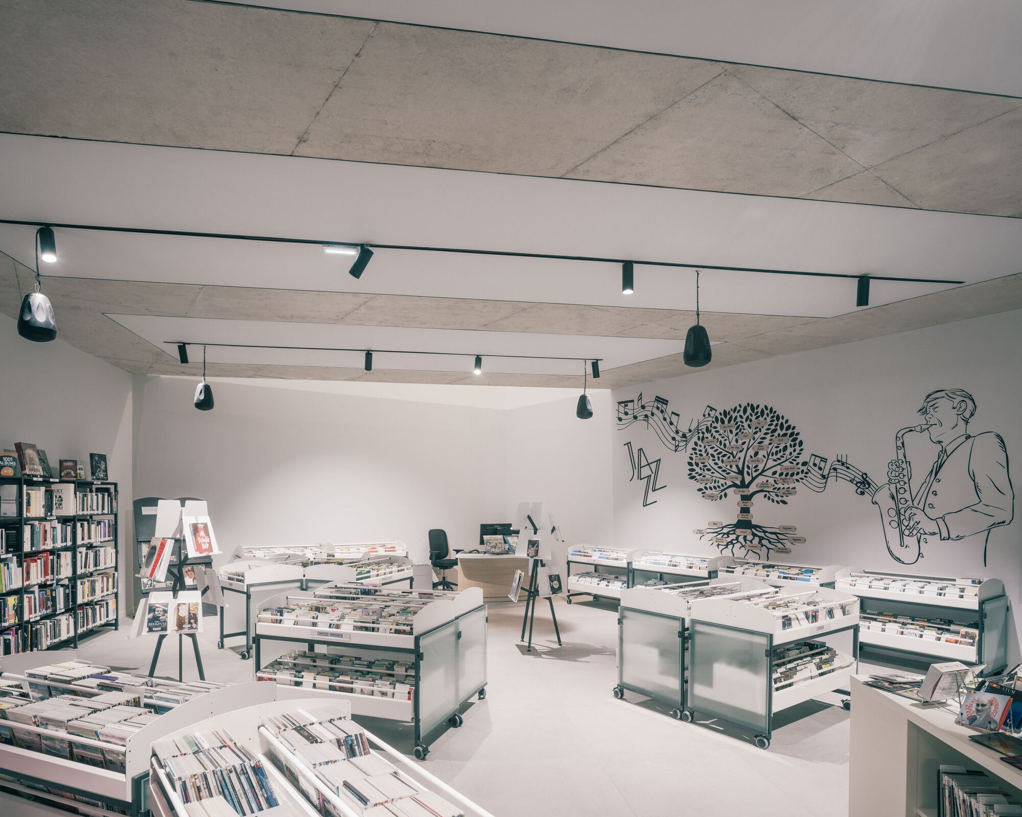 Upper level gallery space with white walls, exposed timber beams and wall mural overlooking display tables