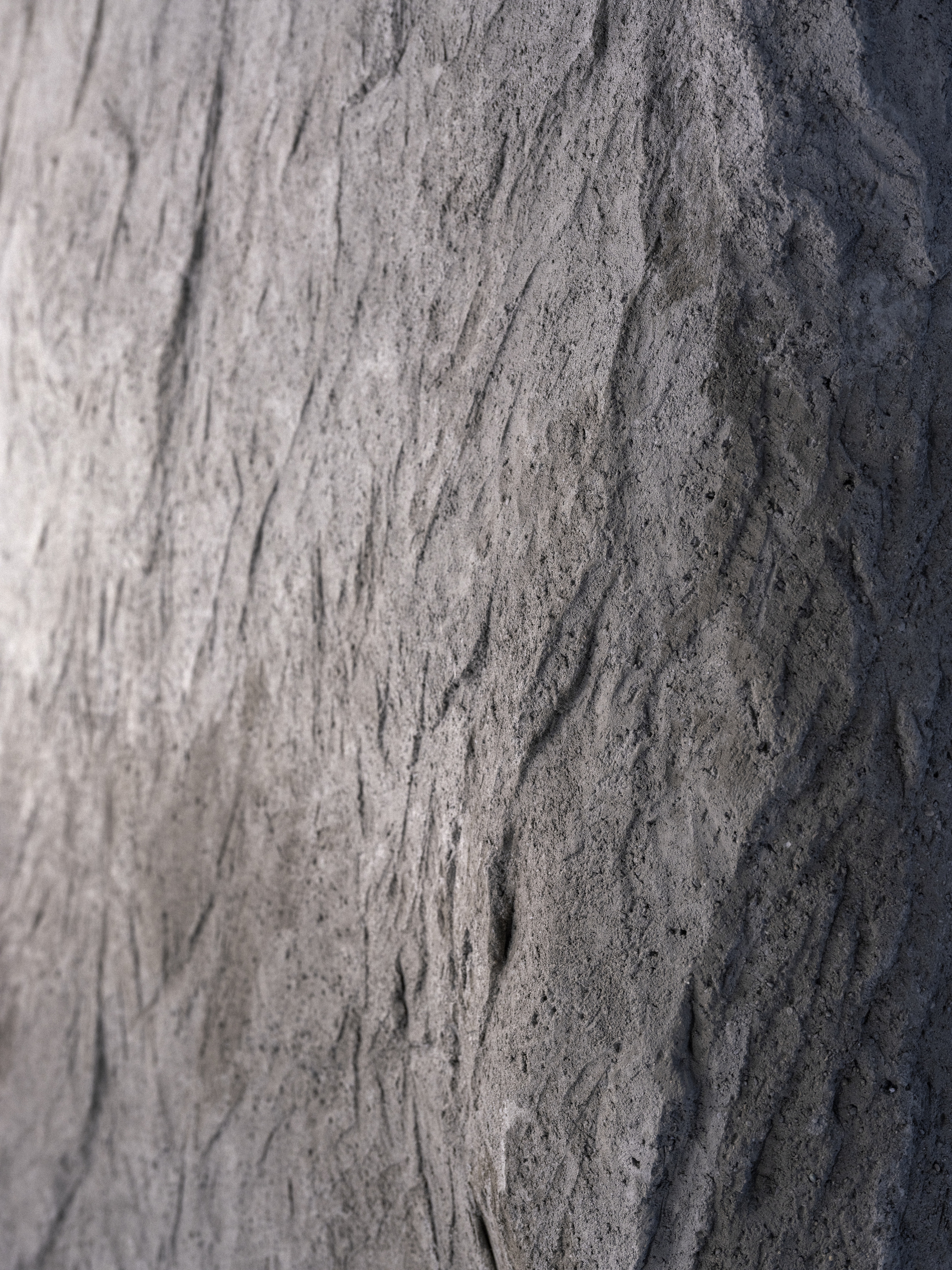 Close-up of textured concrete surface with vertical formwork markings and natural weathering