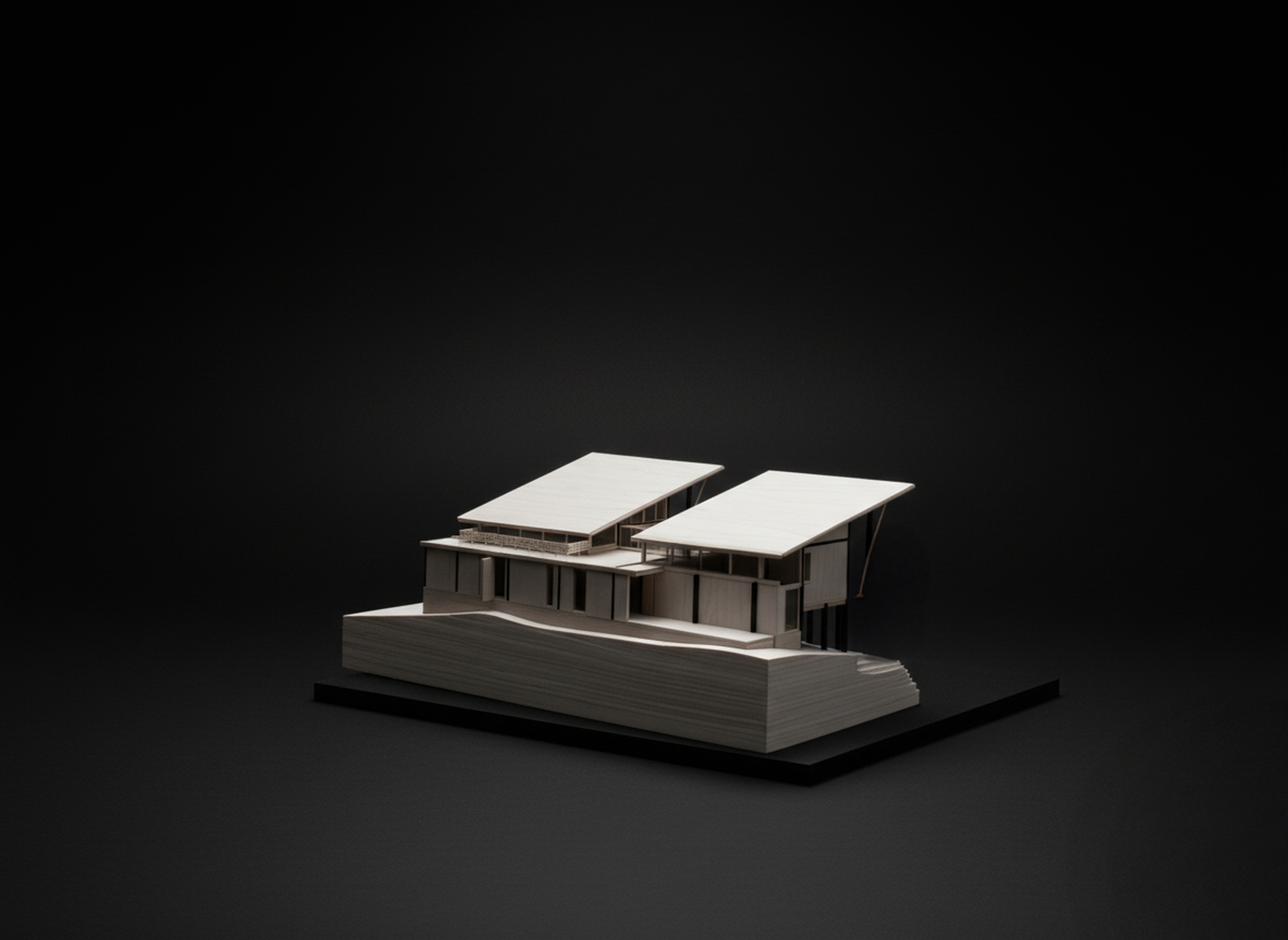Physical model of the residence with two angled roofs on an elevated plinth base