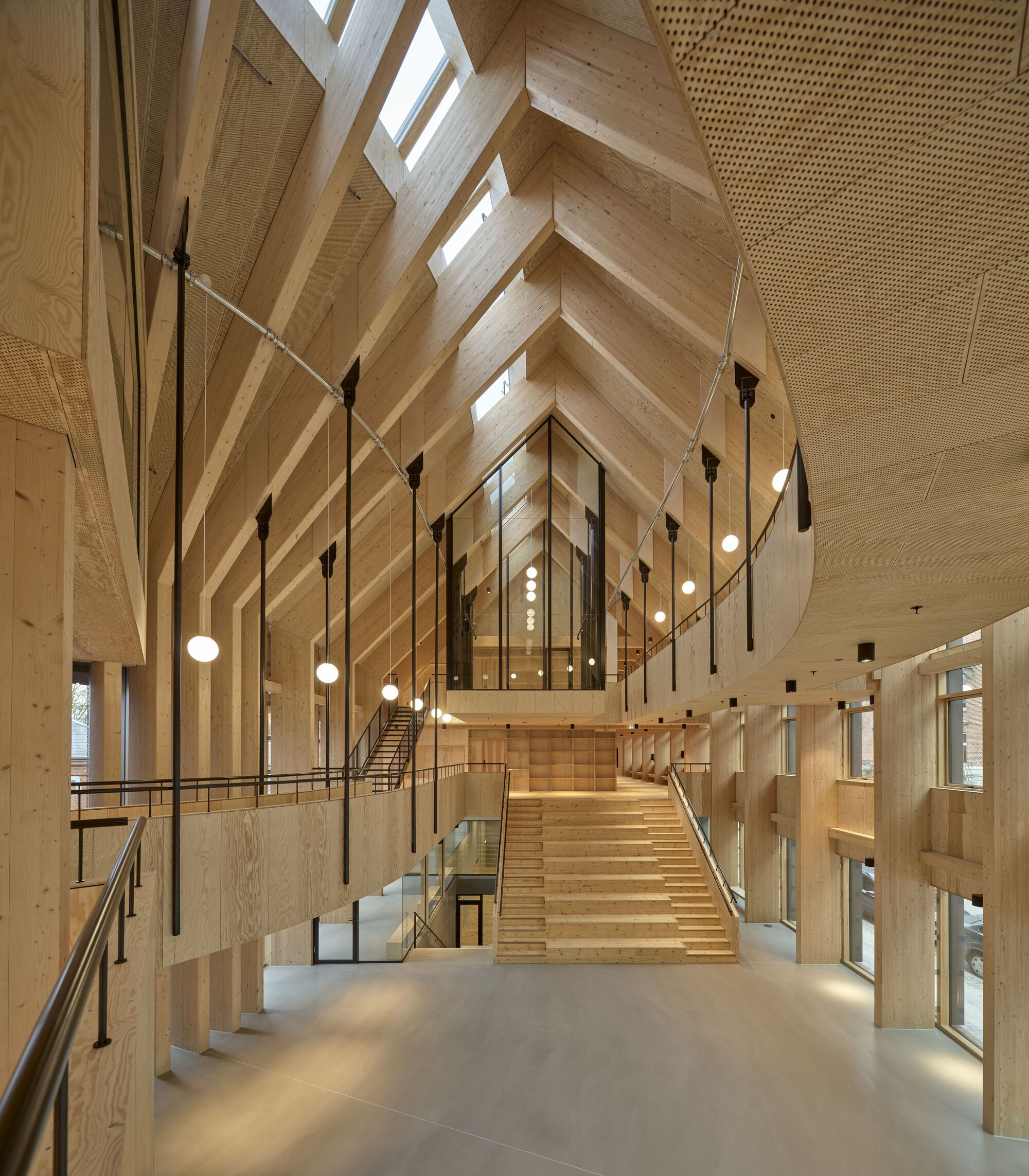 Vaulted timber ceiling above central staircase with suspended globe pendant lights and glass balustrades