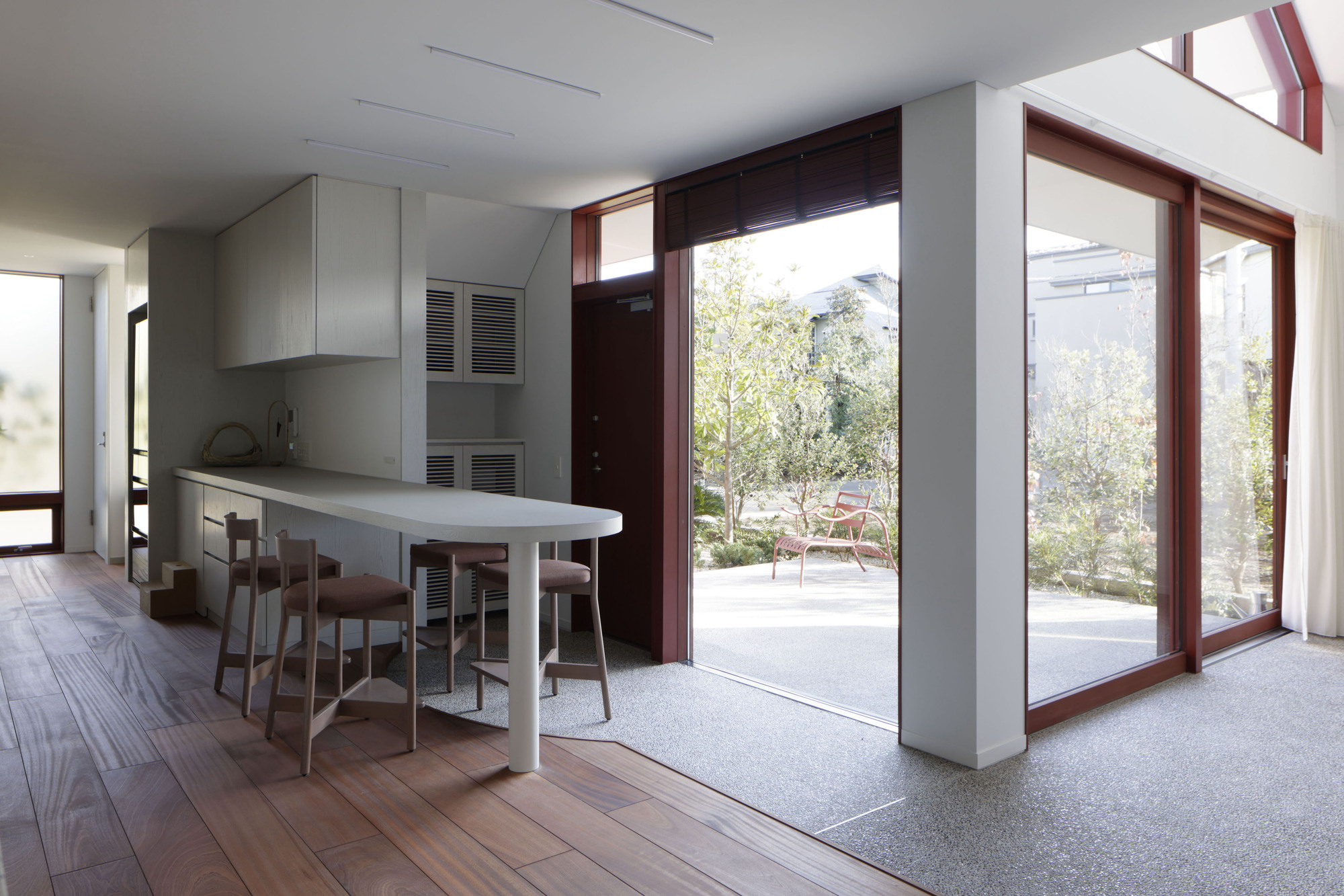 Kitchen and dining area with terrazzo floor threshold and tall mahogany door frames to garden