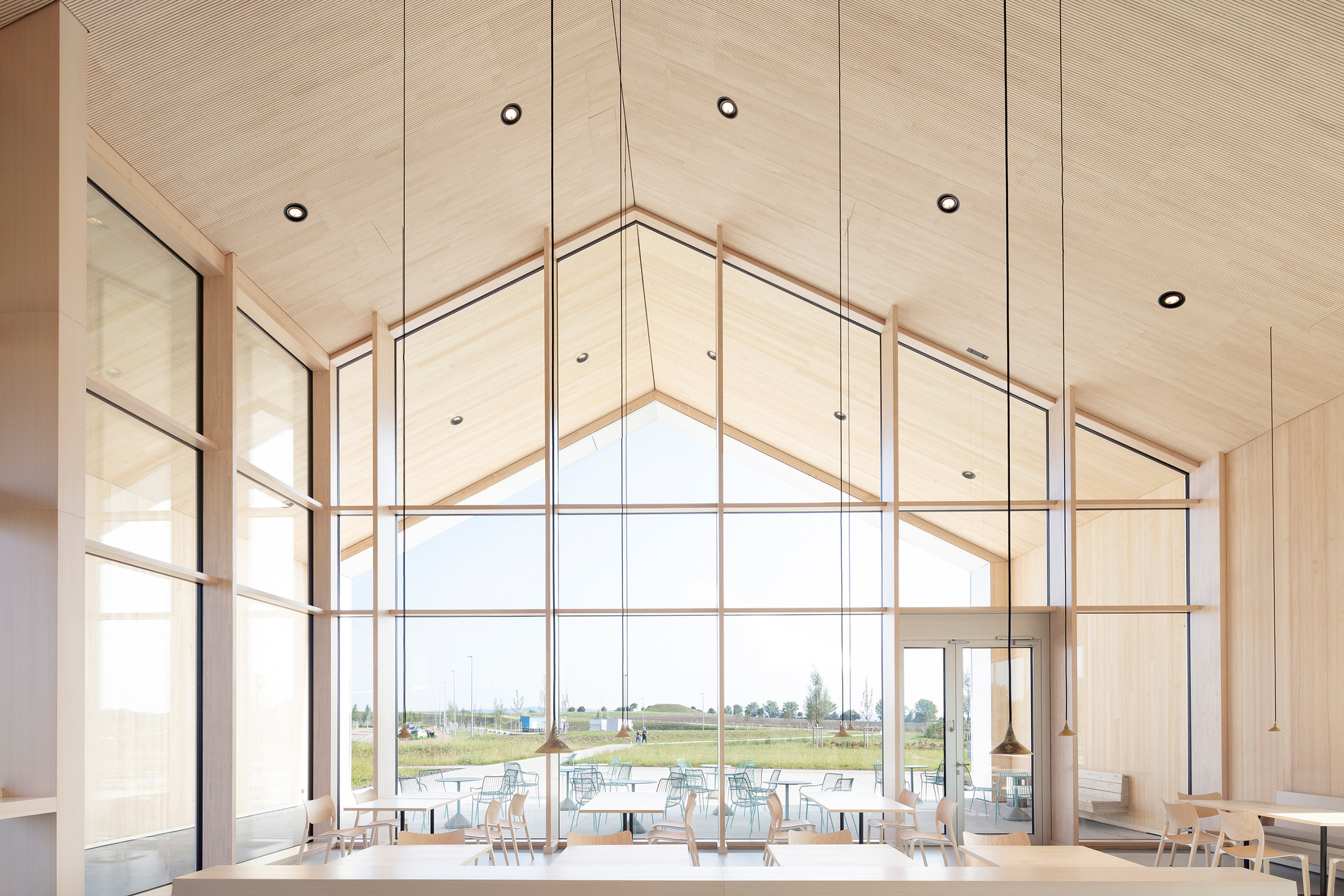 Interior view of the gable window wall with timber mullions and plywood ceiling overlooking the landscape