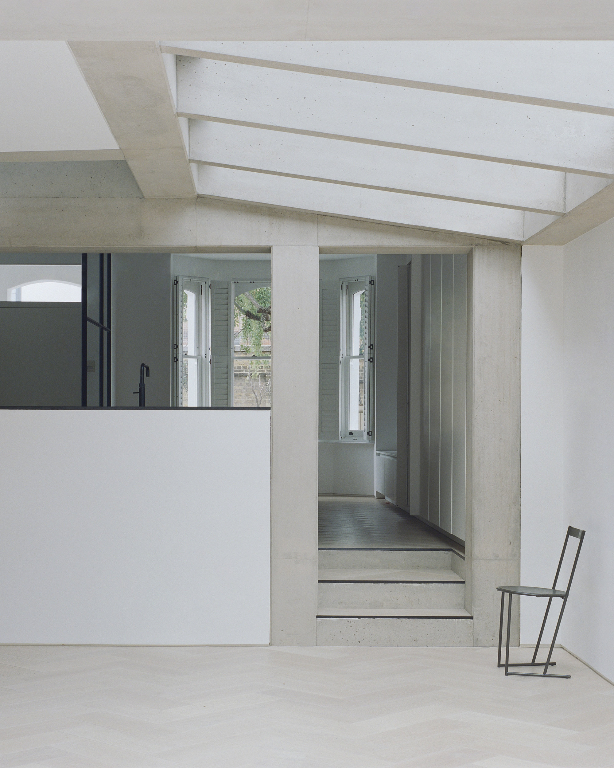Interior view showing concrete steps leading to a corridor with vertical slat paneling