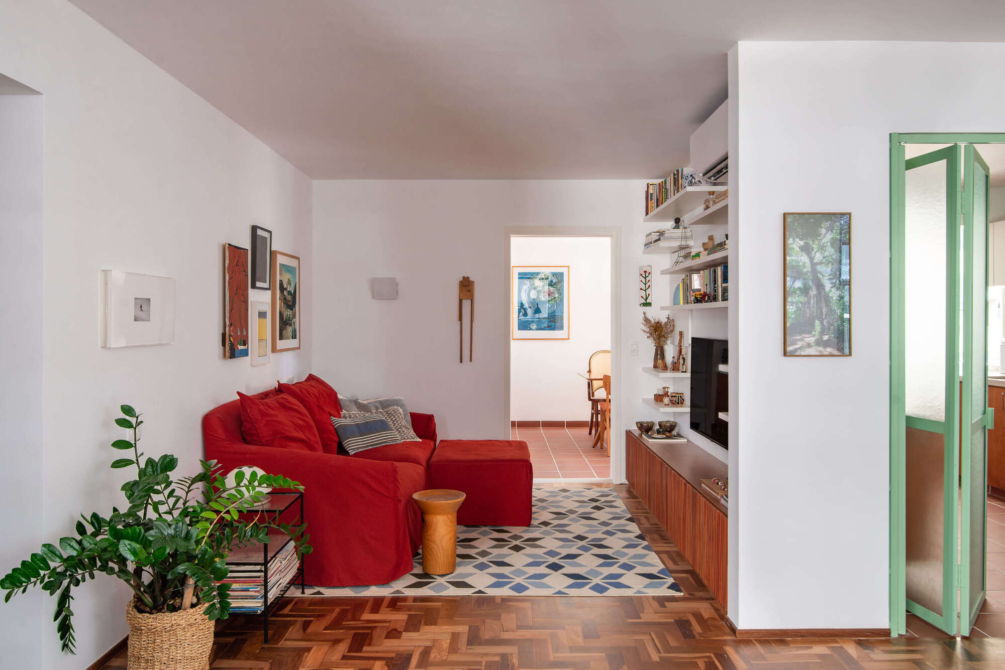 Partial view of the living area showing the transition from herringbone parquet to geometric patterned tile