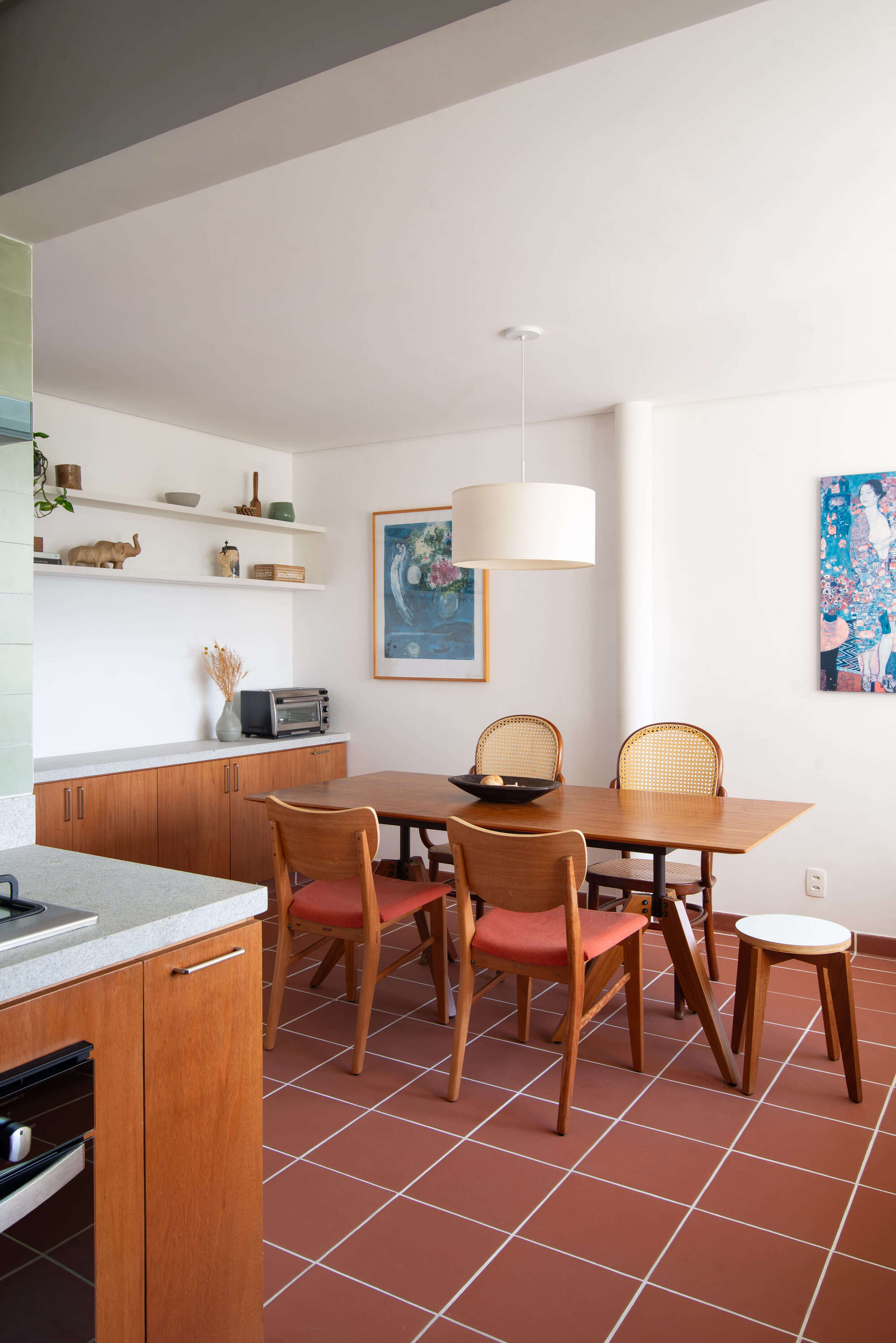 Dining area with terracotta tile floor and timber cabinetry under natural daylight