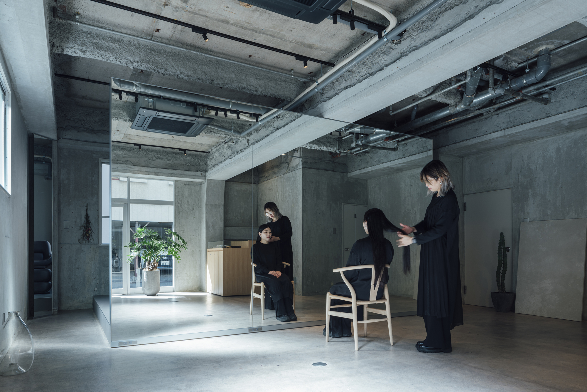 Glass partition dividing the space with three figures in black during a consultation