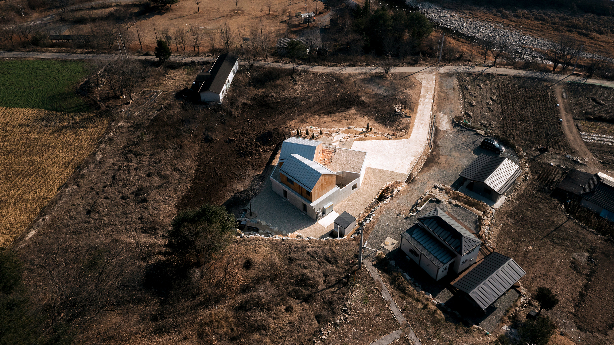 Aerial view of the compound showing the main house and two smaller outbuildings in the landscape