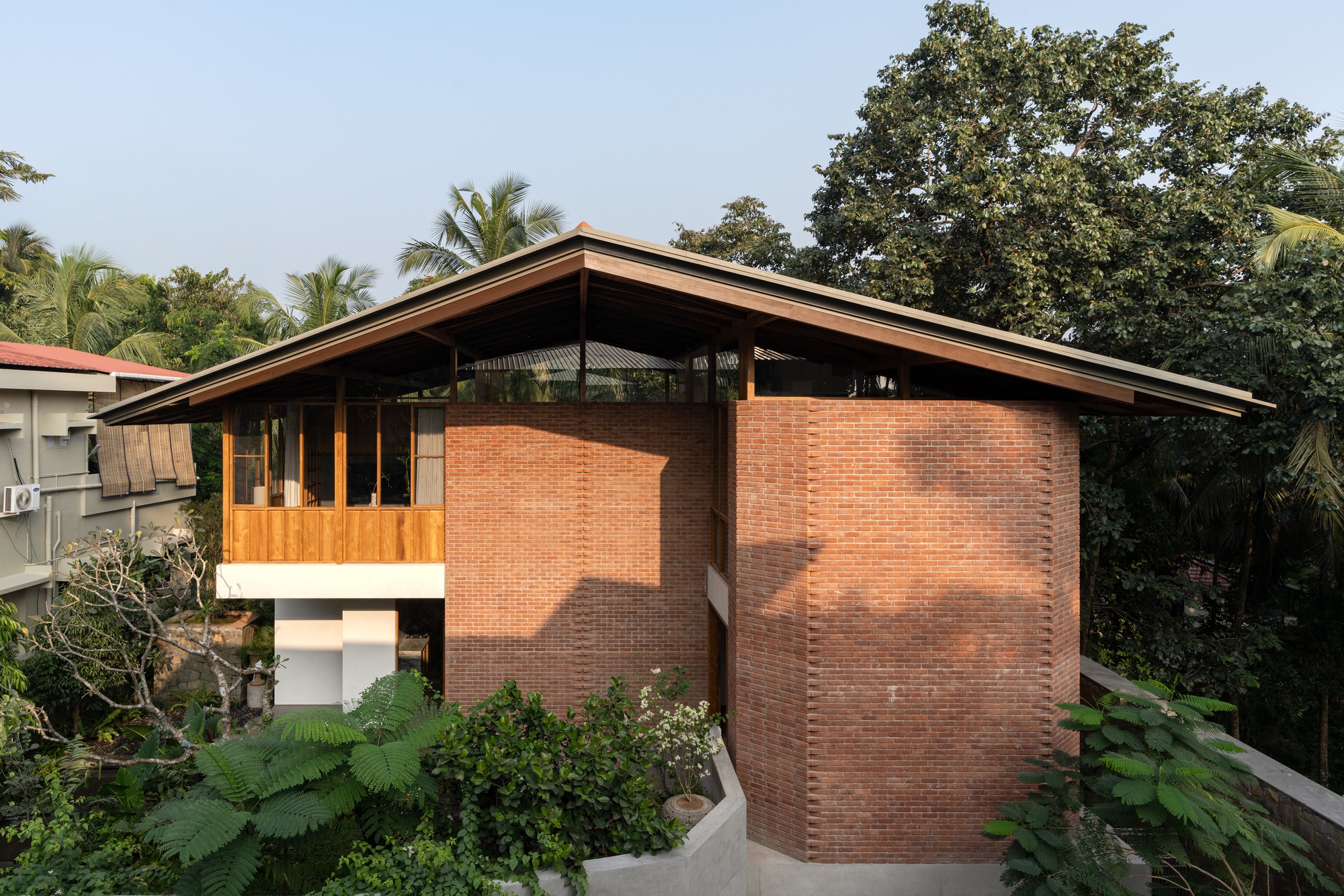 Side elevation showing the cylindrical brick volume and pitched roof with exposed timber structure