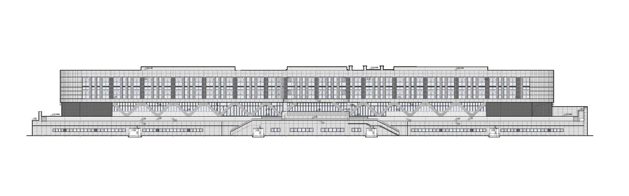 Elevation drawing showing a long horizontal building with a gridded upper facade and stepped lower levels