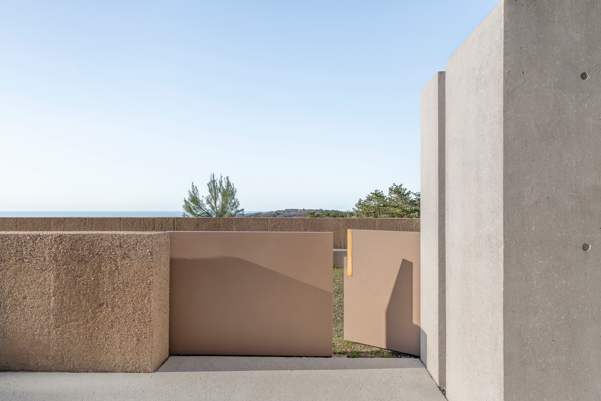 Rooftop terrace corner with textured and smooth concrete walls under open sky