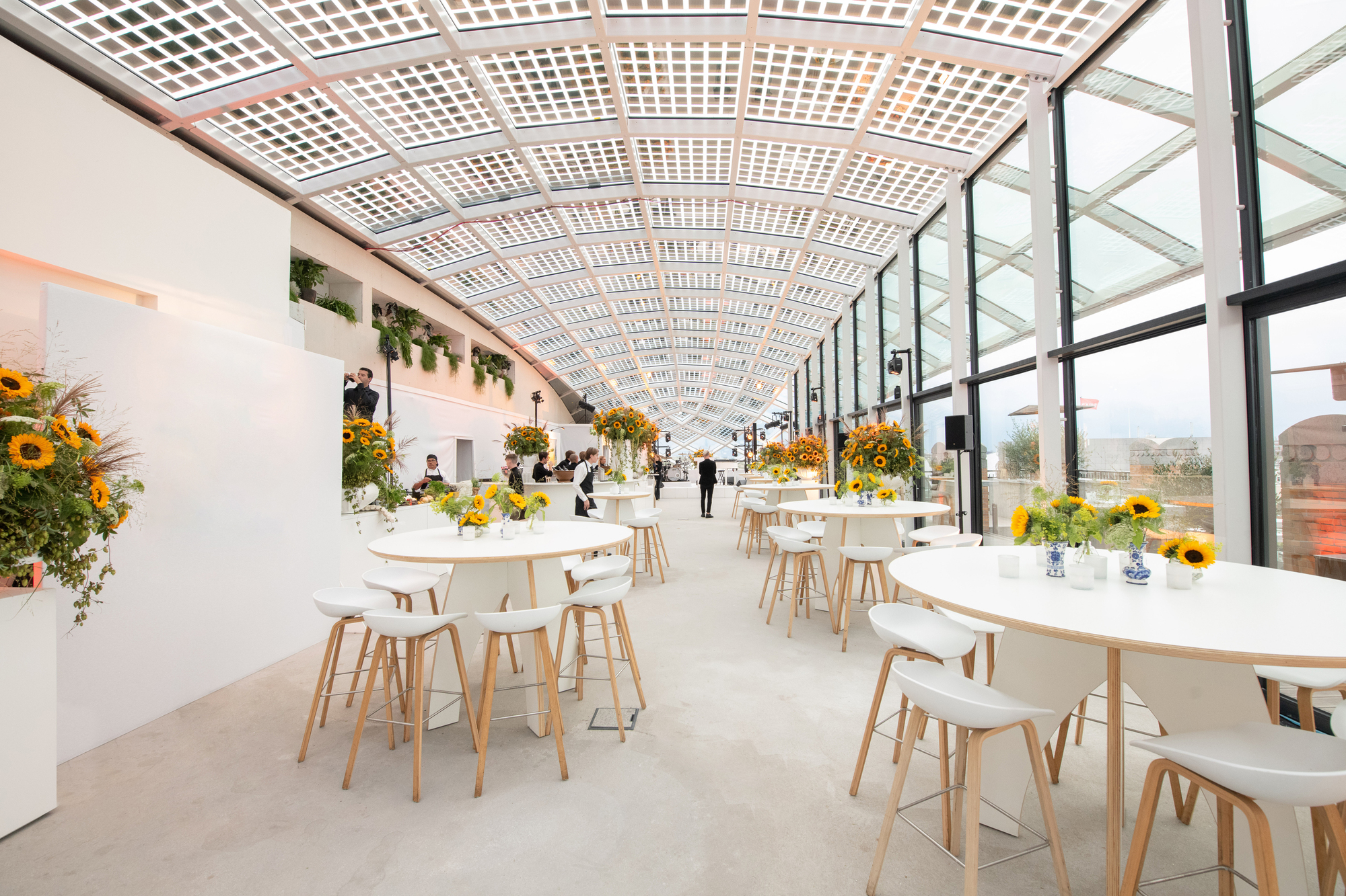 Interior dining space with latticed curved ceiling and floor-to-ceiling glazing along one side