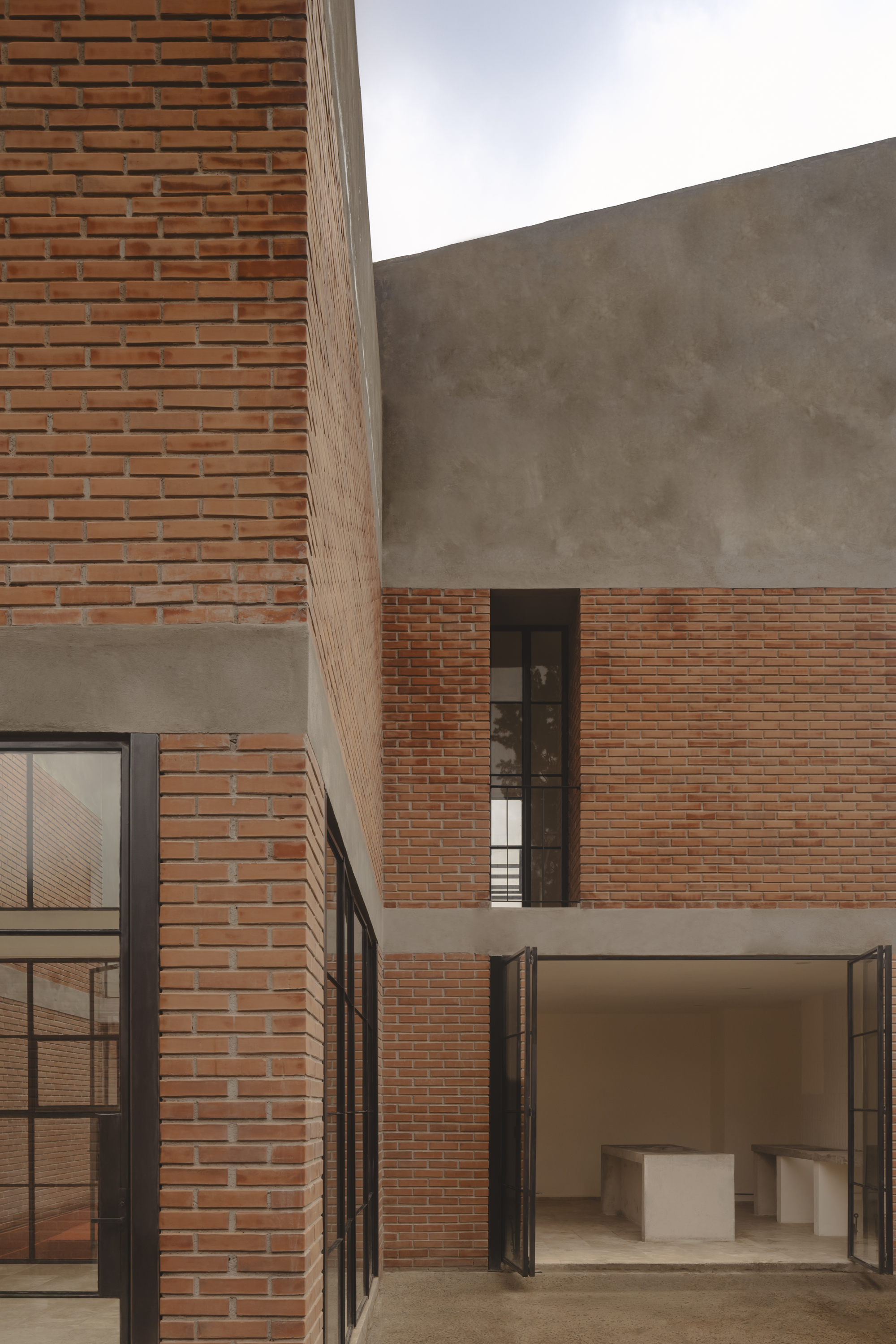 Interior courtyard showing interlocking brick and concrete volumes under diffused daylight