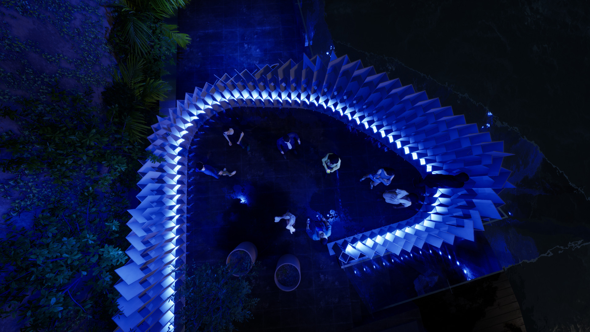 Overhead view of curved illuminated seating installation encircling visitors gathered at night beneath palm trees