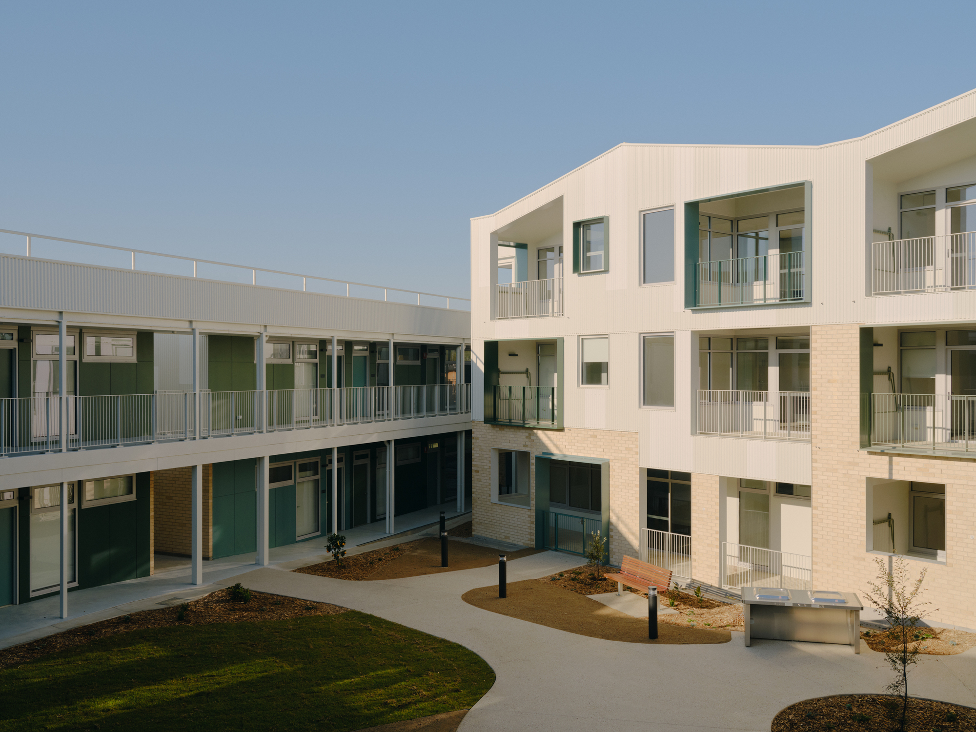 Central courtyard with oval lawn and three-storey housing units on two sides