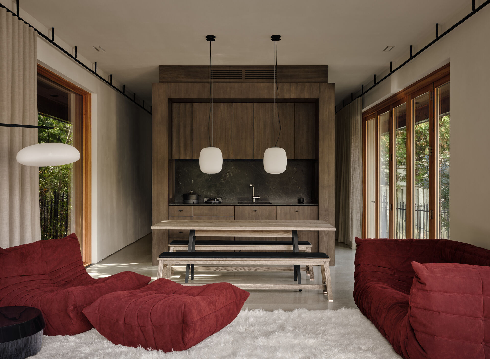 Interior looking toward timber kitchen unit with pendant lights and flanking glazed openings