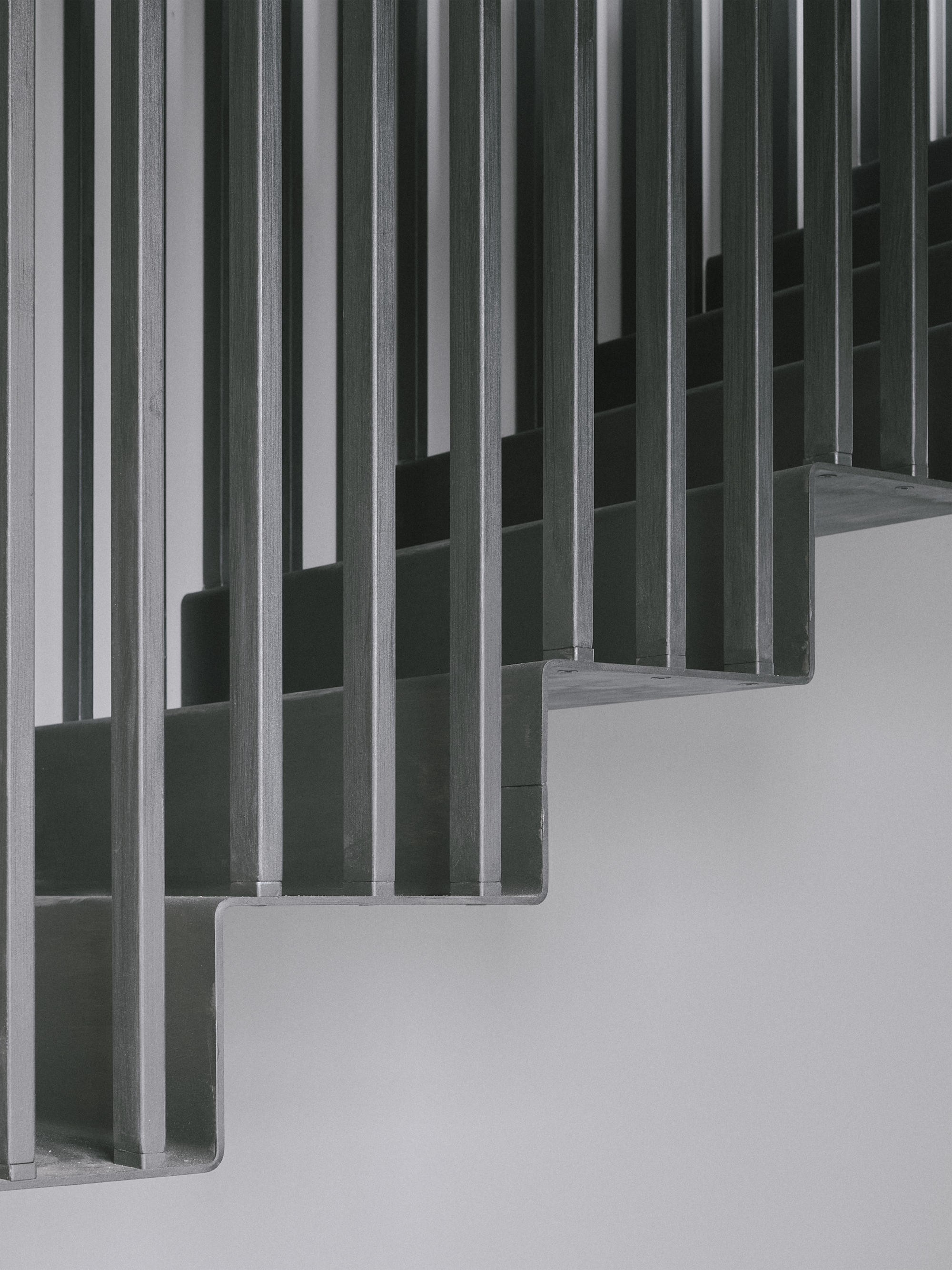 Close-up of vertical timber slat screens forming a rhythmic pattern against a white wall