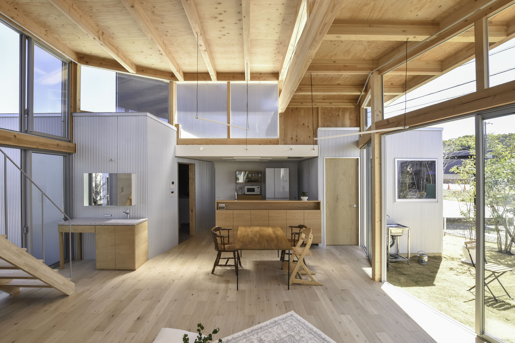 Timber-framed mezzanine level overlooking the dining area and courtyard garden beyond