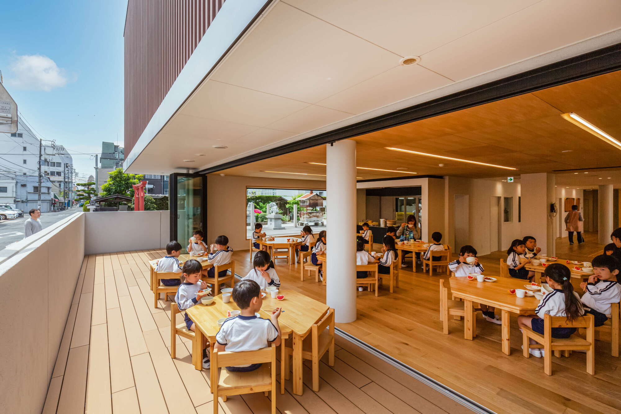 Open dining area with sliding glass doors to a timber deck and children seated at tables