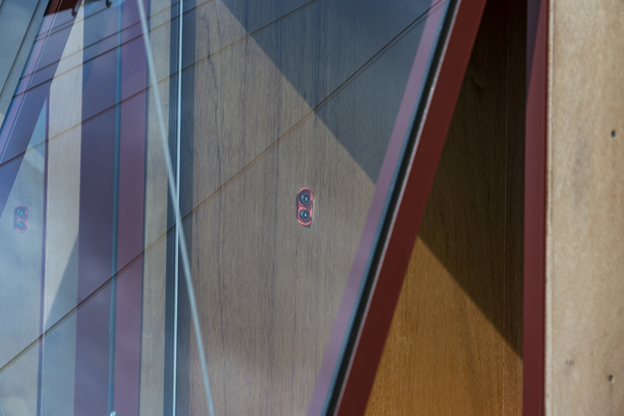 Curved corrugated metal wall reflecting daylight with electrical outlets and adjoining wood panels