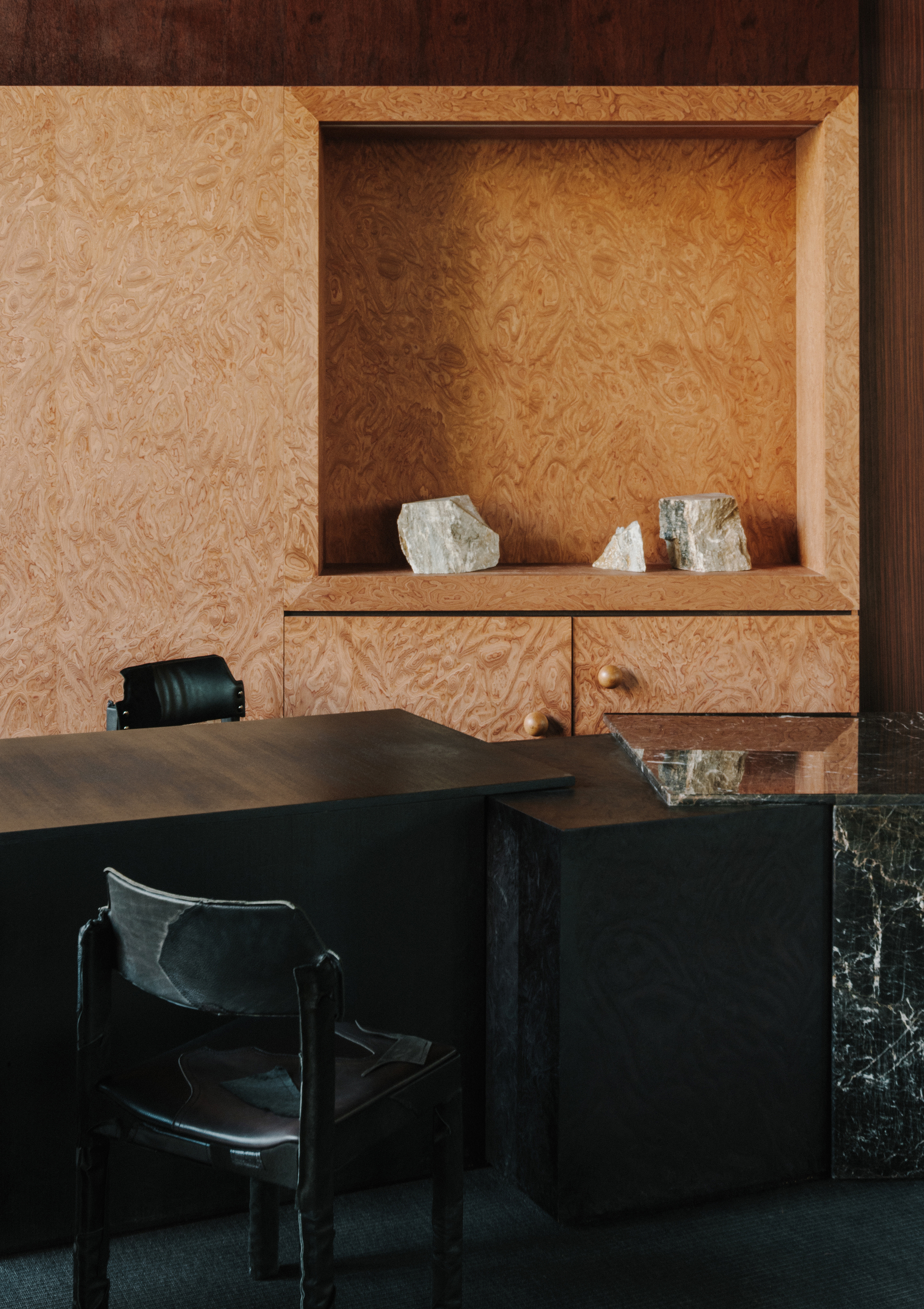 Recessed niche in oriented strand board millwork displaying three chunks of raw quartz crystal