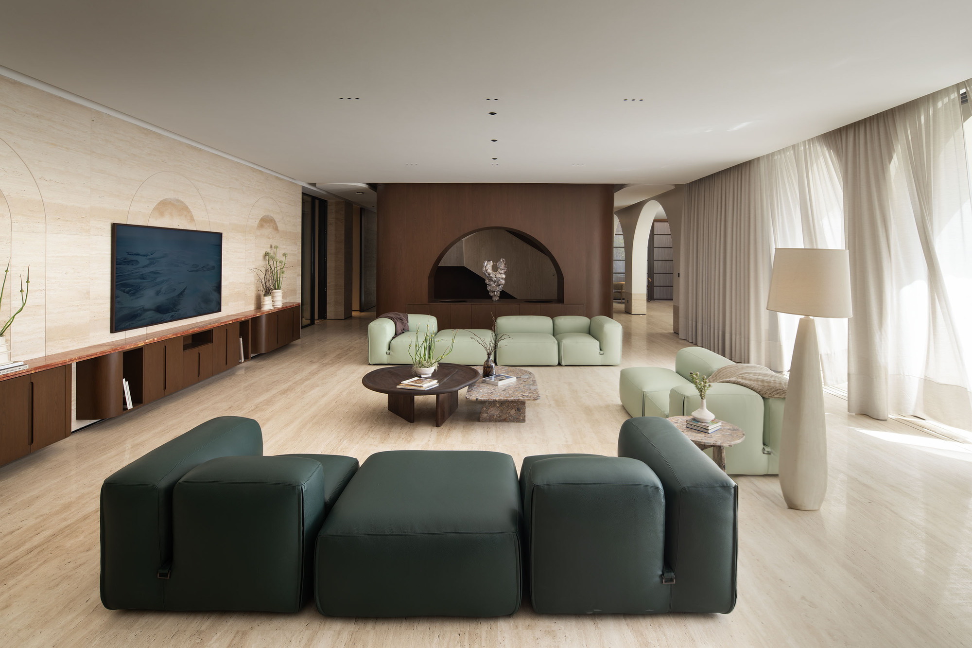 Living area with arched brown-toned wall niche and sheer curtains along the window wall