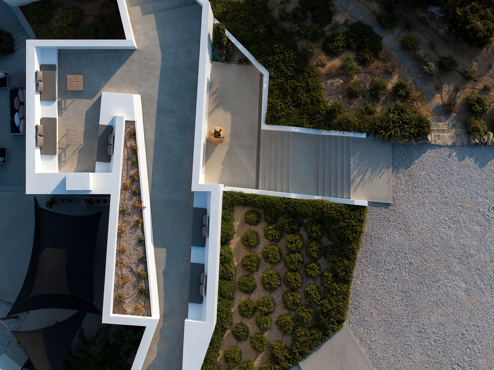 Aerial view showing the white rooftop terraces with timber decking and gravel landscaping below