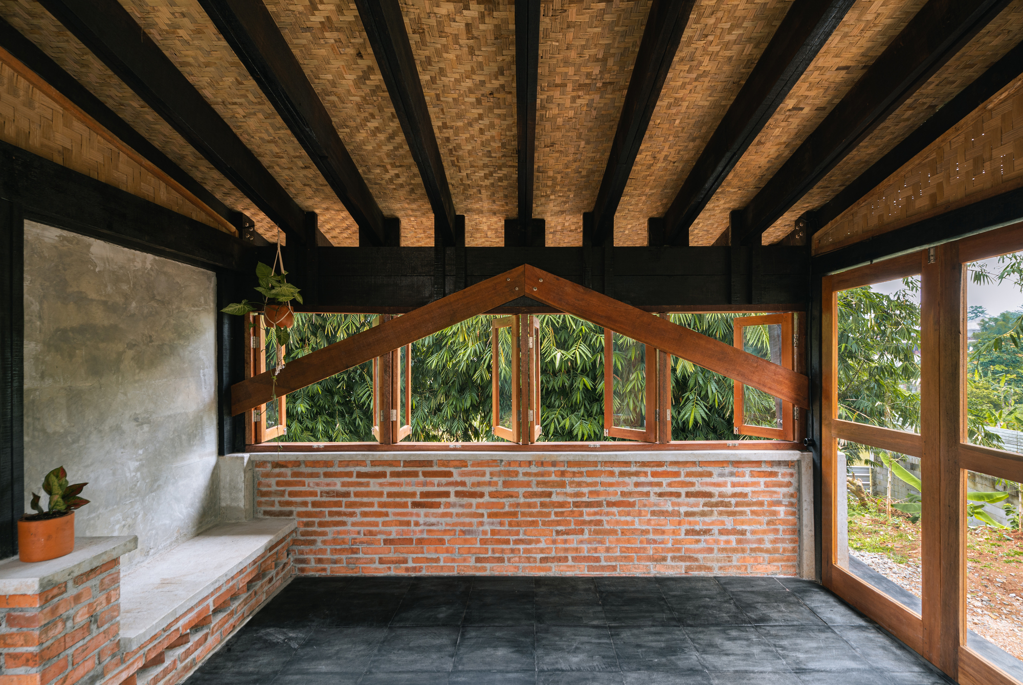 Corner bench detail with brick base and timber-framed windows under woven ceiling