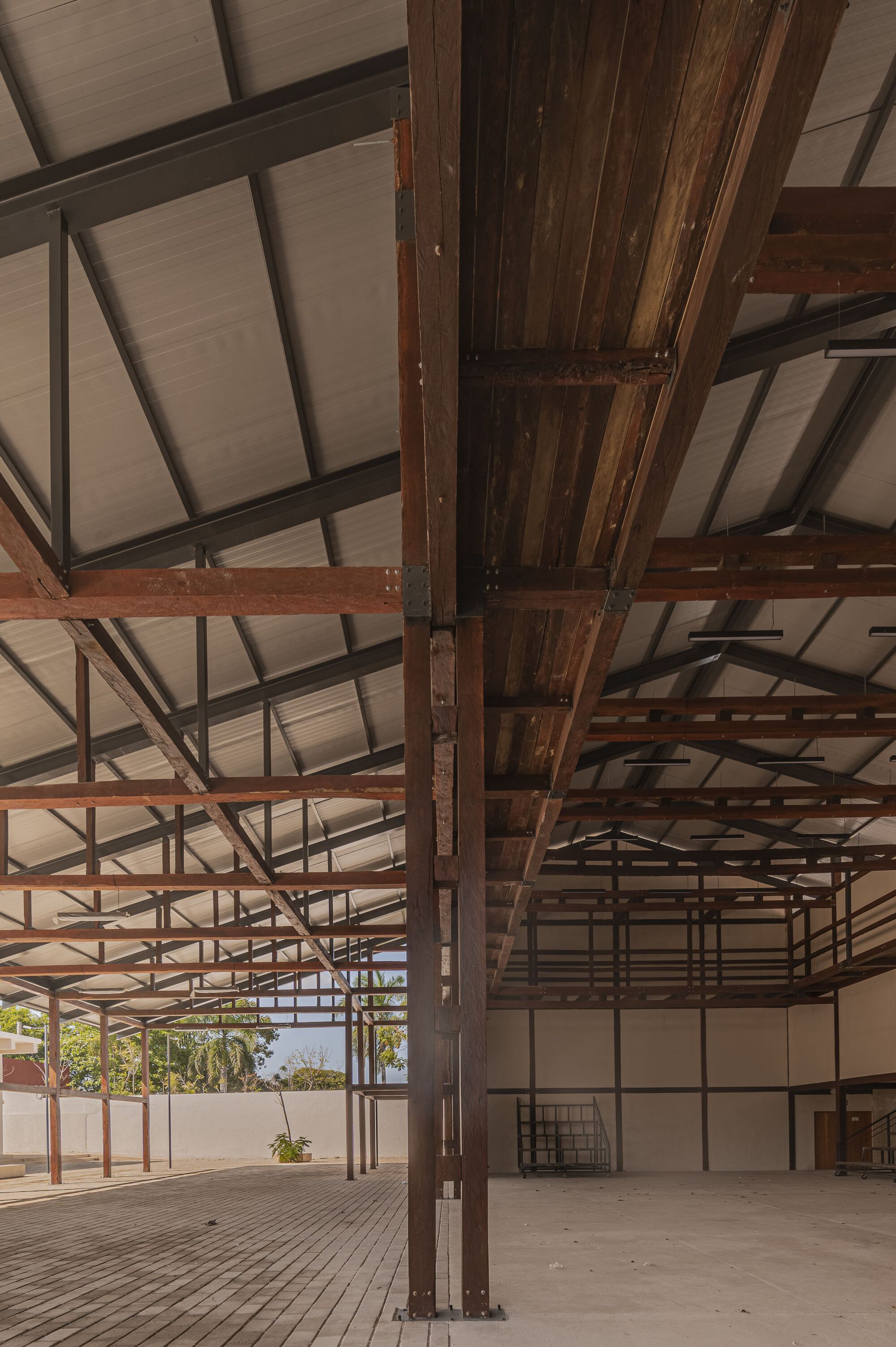 Close-up of timber beam and steel column connection beneath the gridded ceiling structure